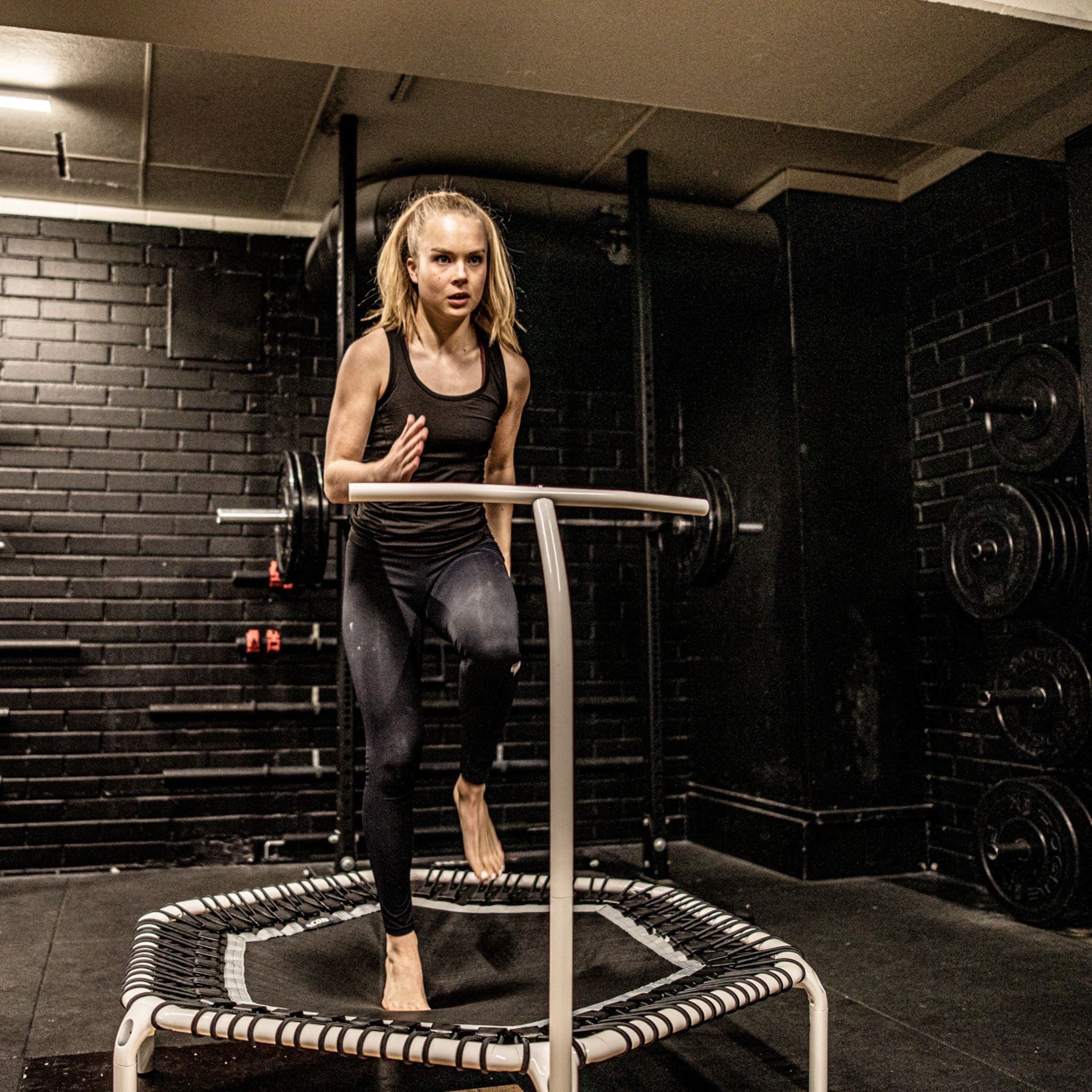 Eine Frau trainiert auf einem Fitness-Trampolin, um ihre Ausdauer und Fitness zu verbessern.