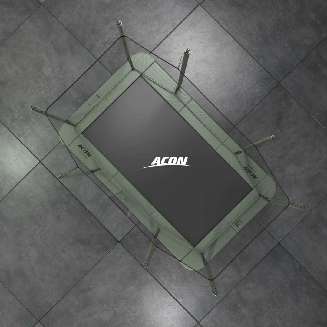 Acon HD rechteckiges Trampolin aus der Vogelperspektive vor grauem Hintergrund. Die schwarze Trampolinmatte hat ein ACON-Logo in Weiß und die Polsterung ist grün