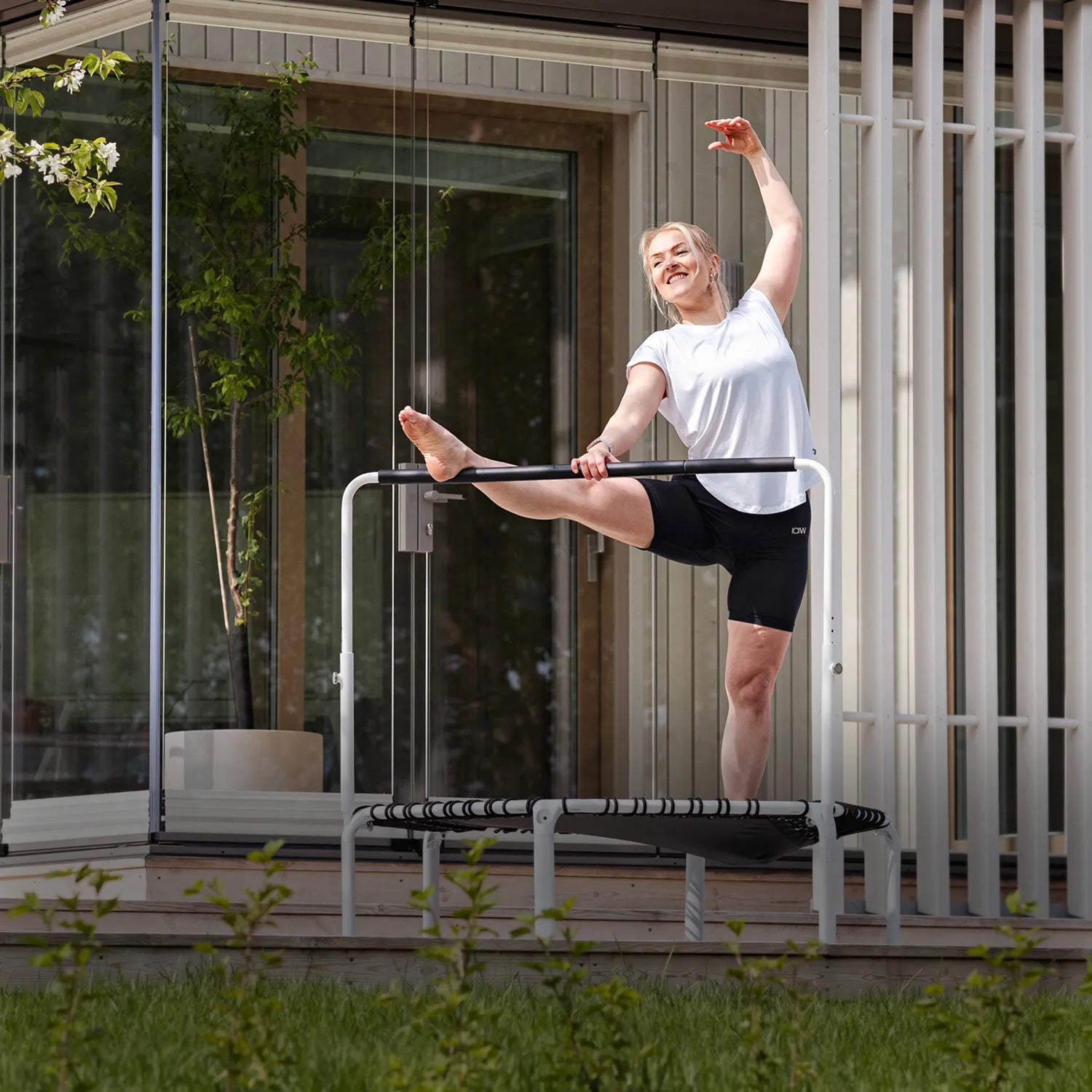 ACON Fit 1,12 m Runder Rebounder mit Balance-Haltestange beim Stretching im Freien auf der Terrasse.