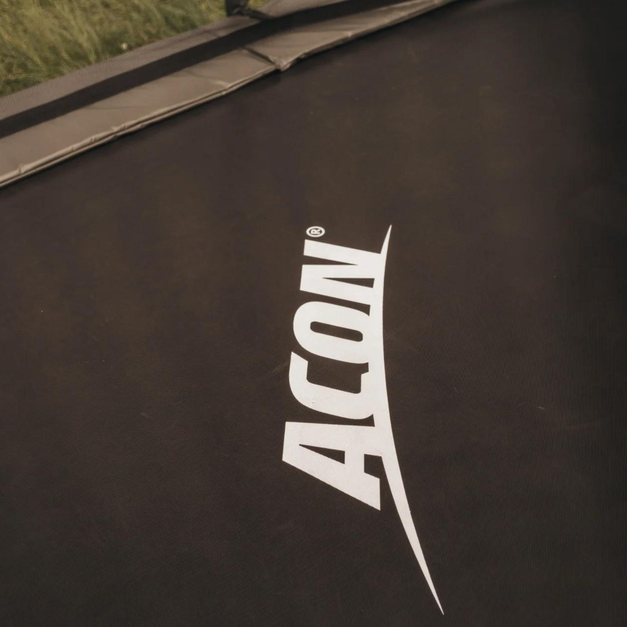 Schwarzes Acon Trampolin mit Logo im Garten