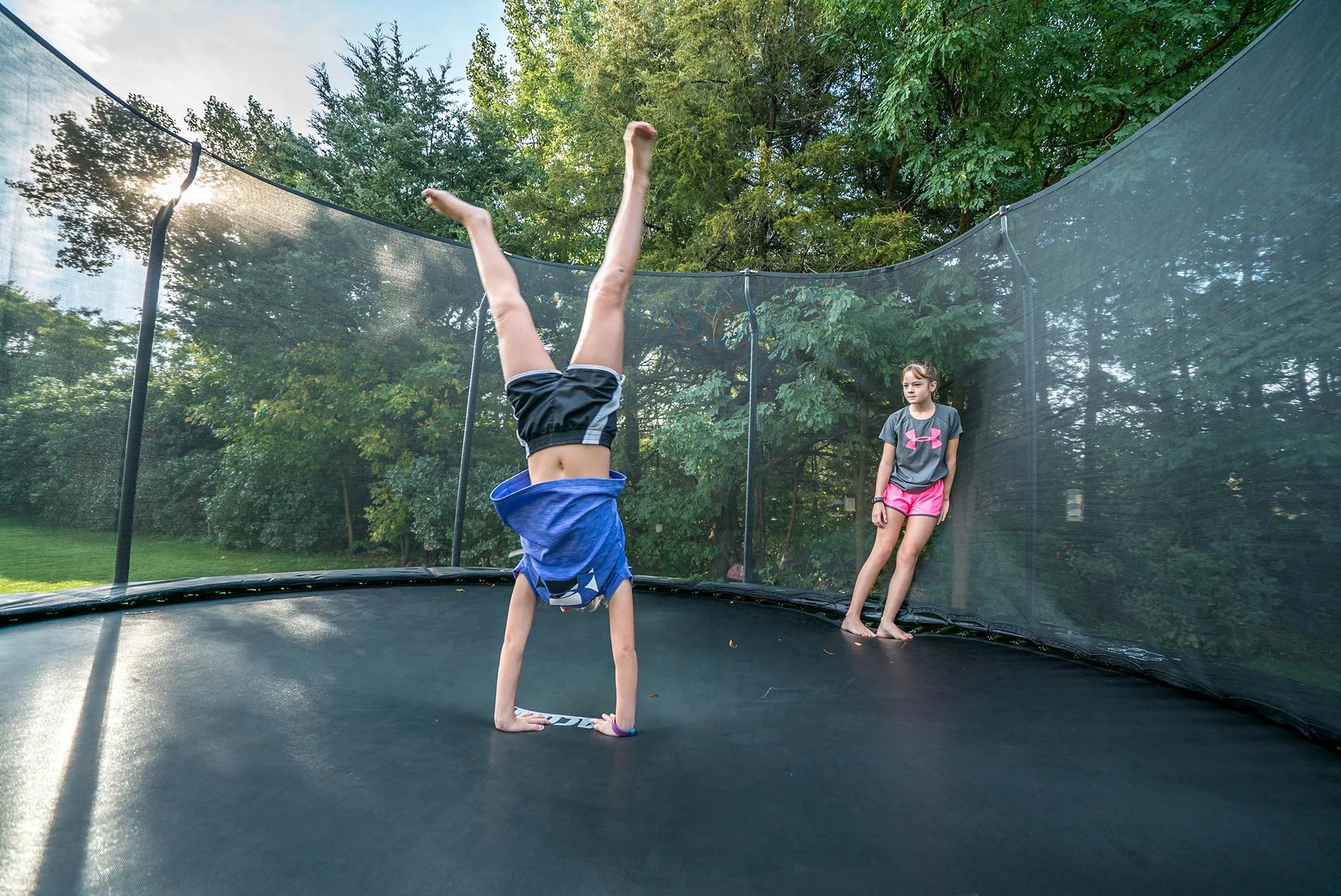 Kinder auf Trampolin im Garten