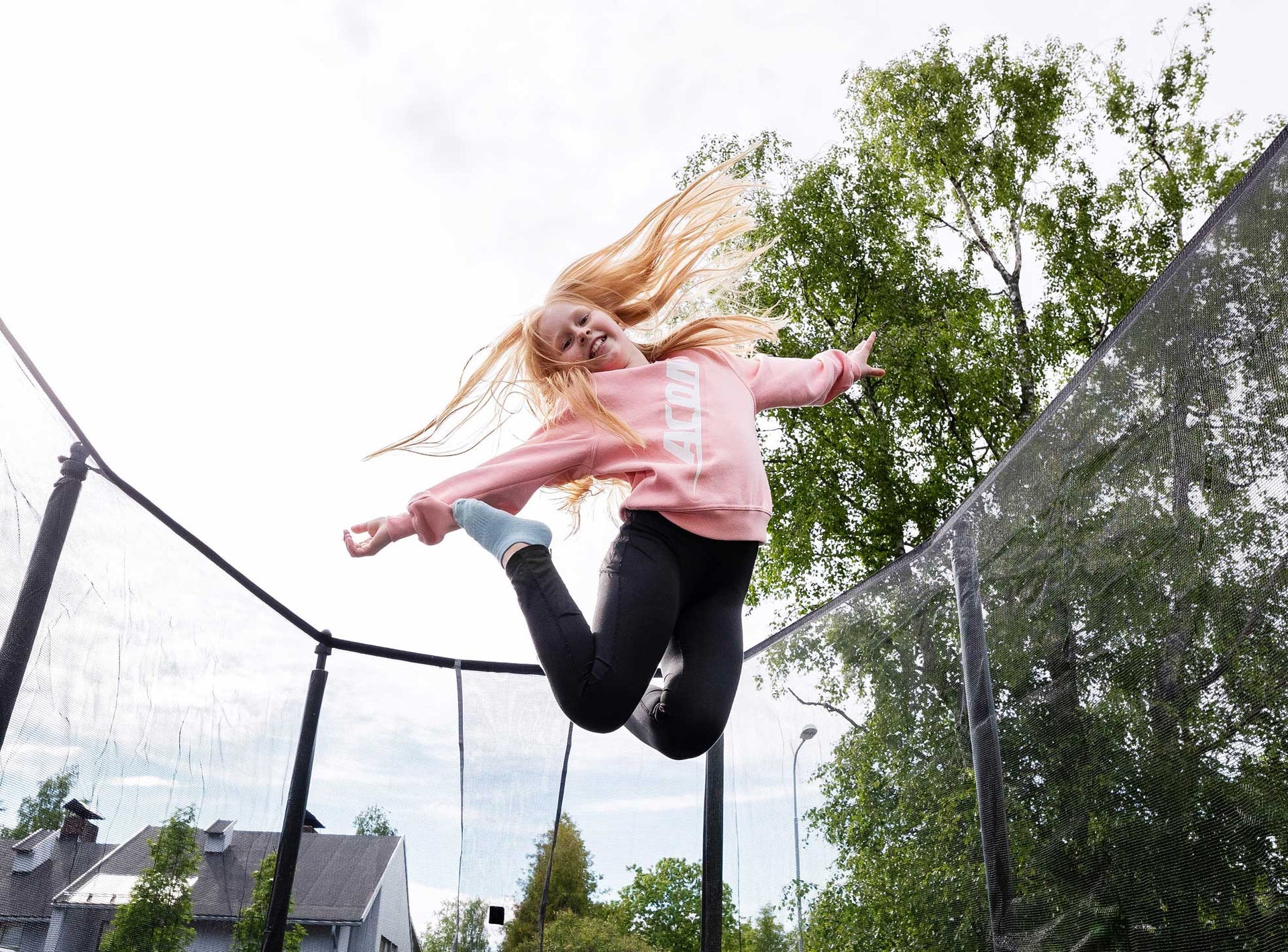Kleines Maedchen springt auf Trampolin
