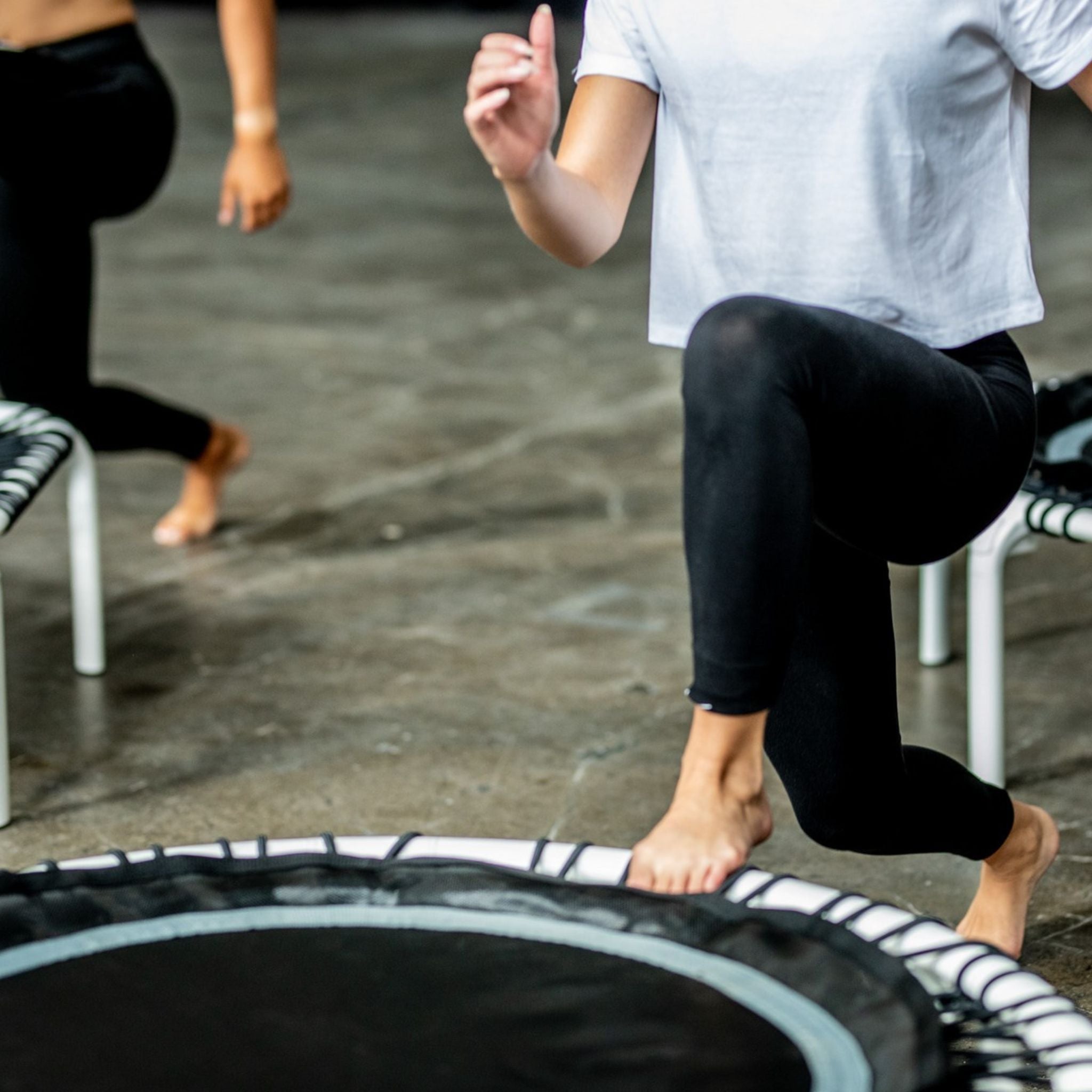 Frau trainiert low Lunges auf einem Trampolin
