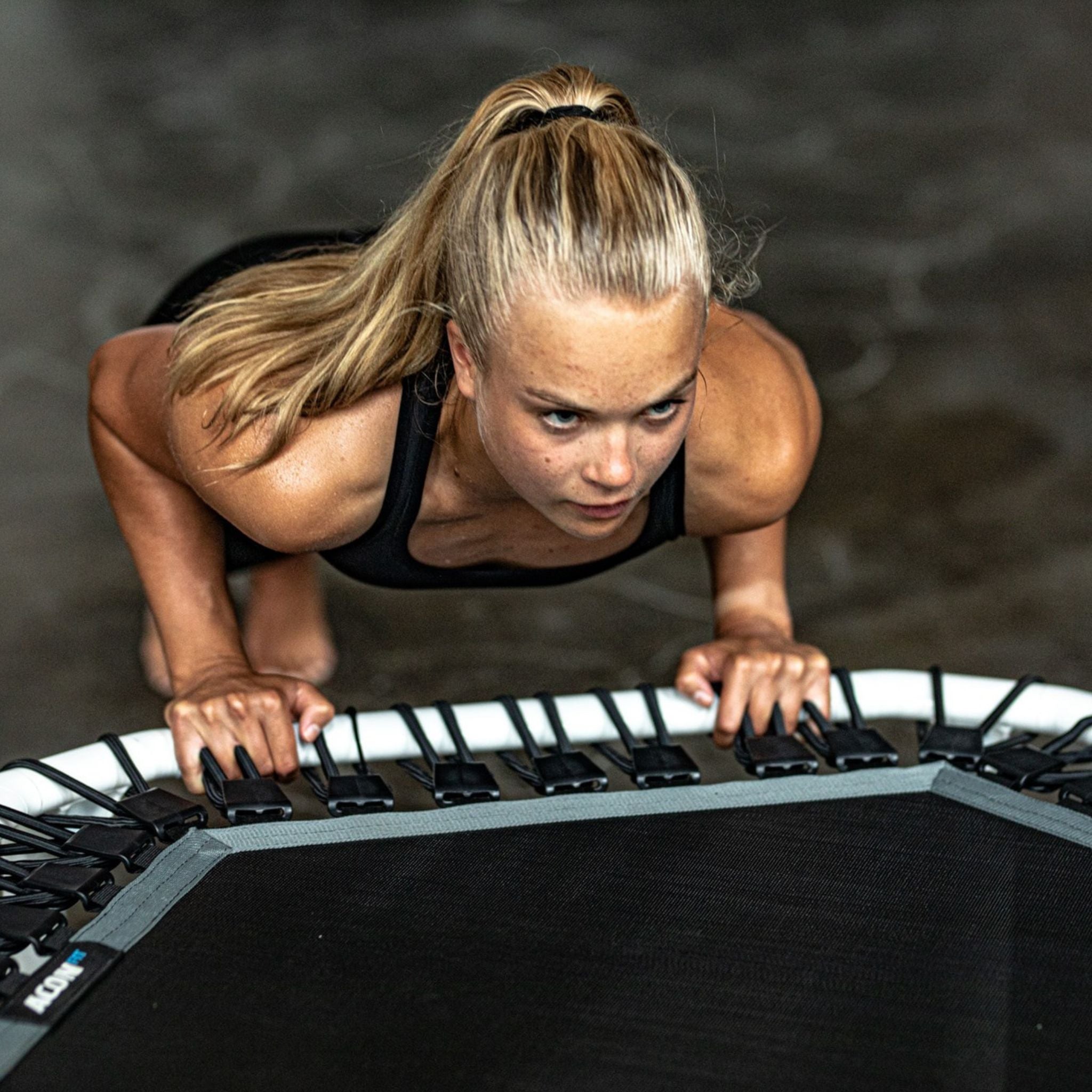 Frau trainiert Liegestütze auf einem Trampolin
