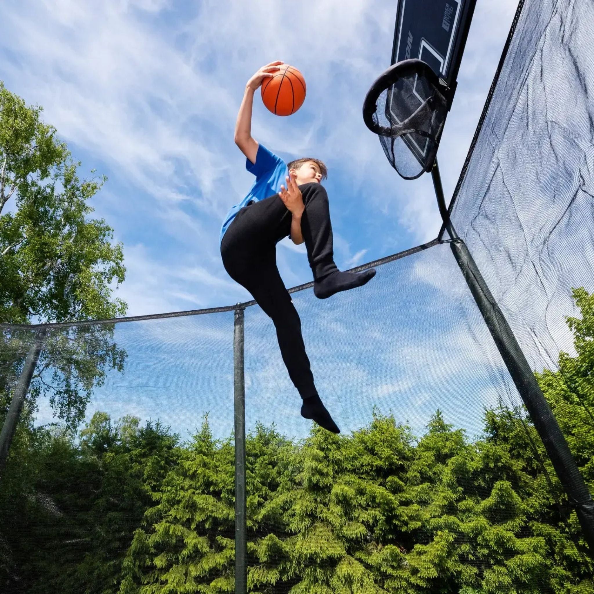 Junge spielt Basketball auf Riesen Trampolin
