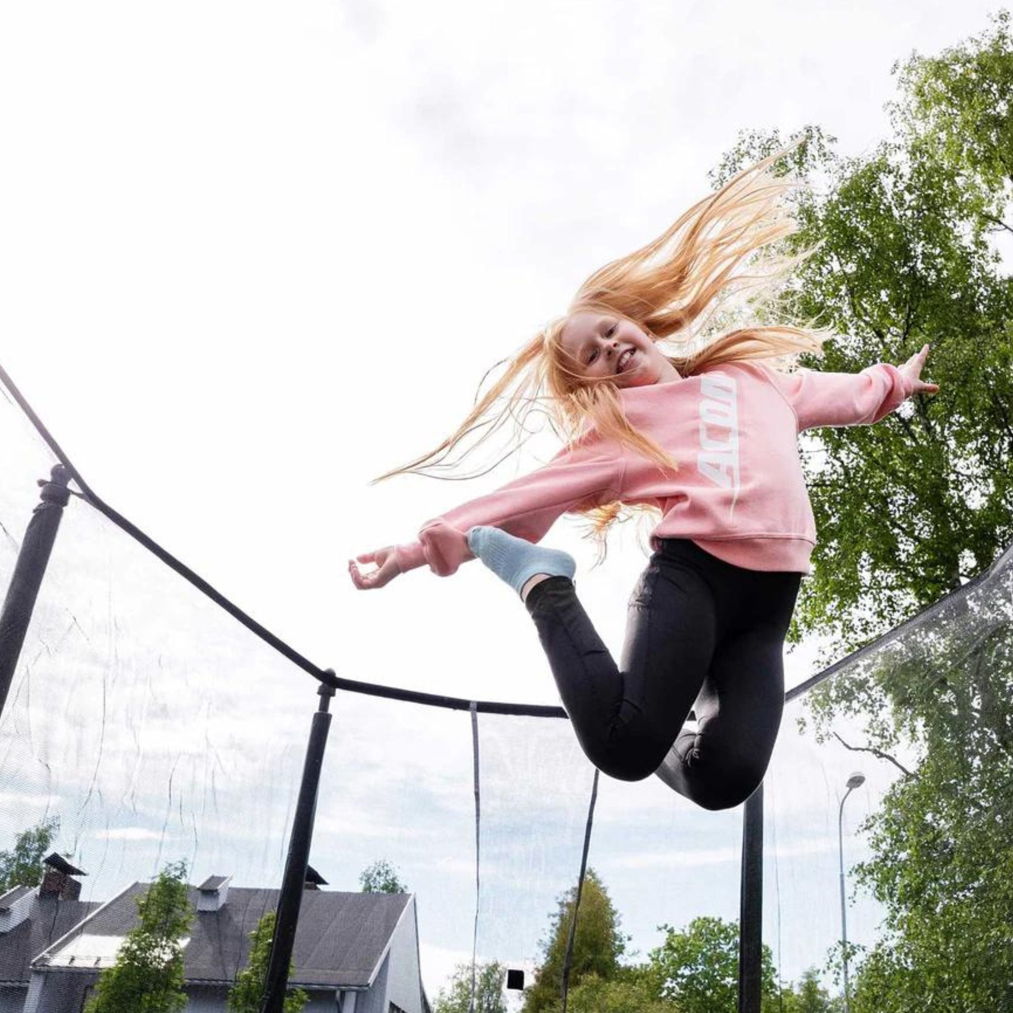 Kind auf Trampolin. Trampolin im Garten verboten.