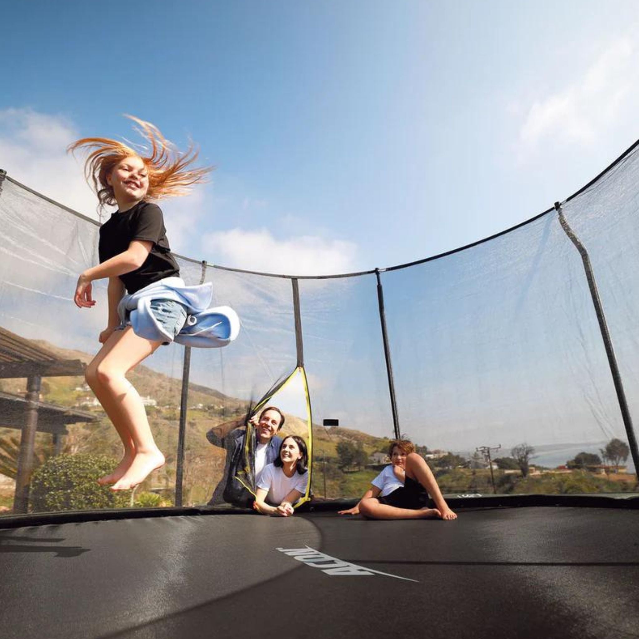 Mädchen hüpft Trampolin im Garten. Trampolin Regeln
