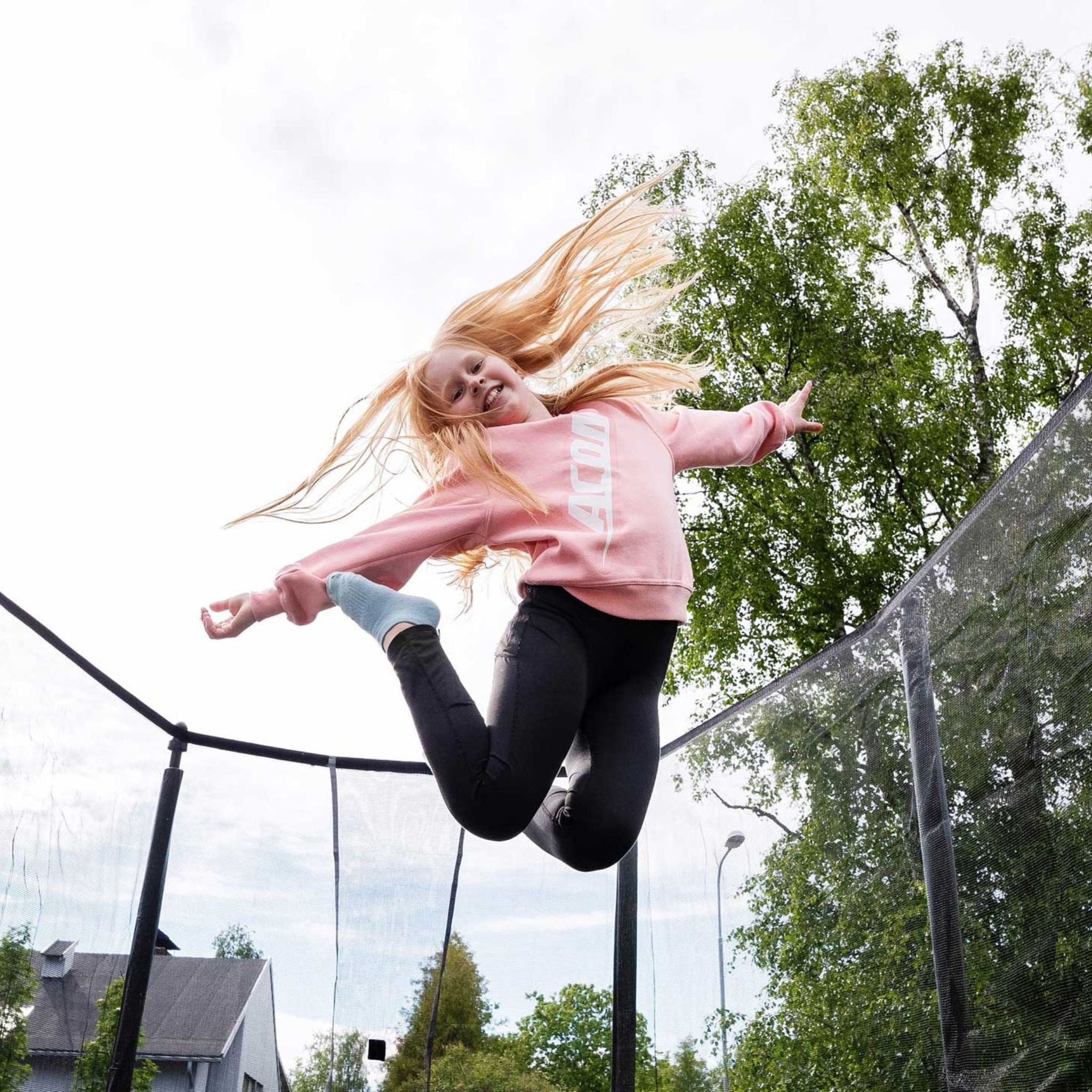 Kind springt mit Socken auf dem Trampolin