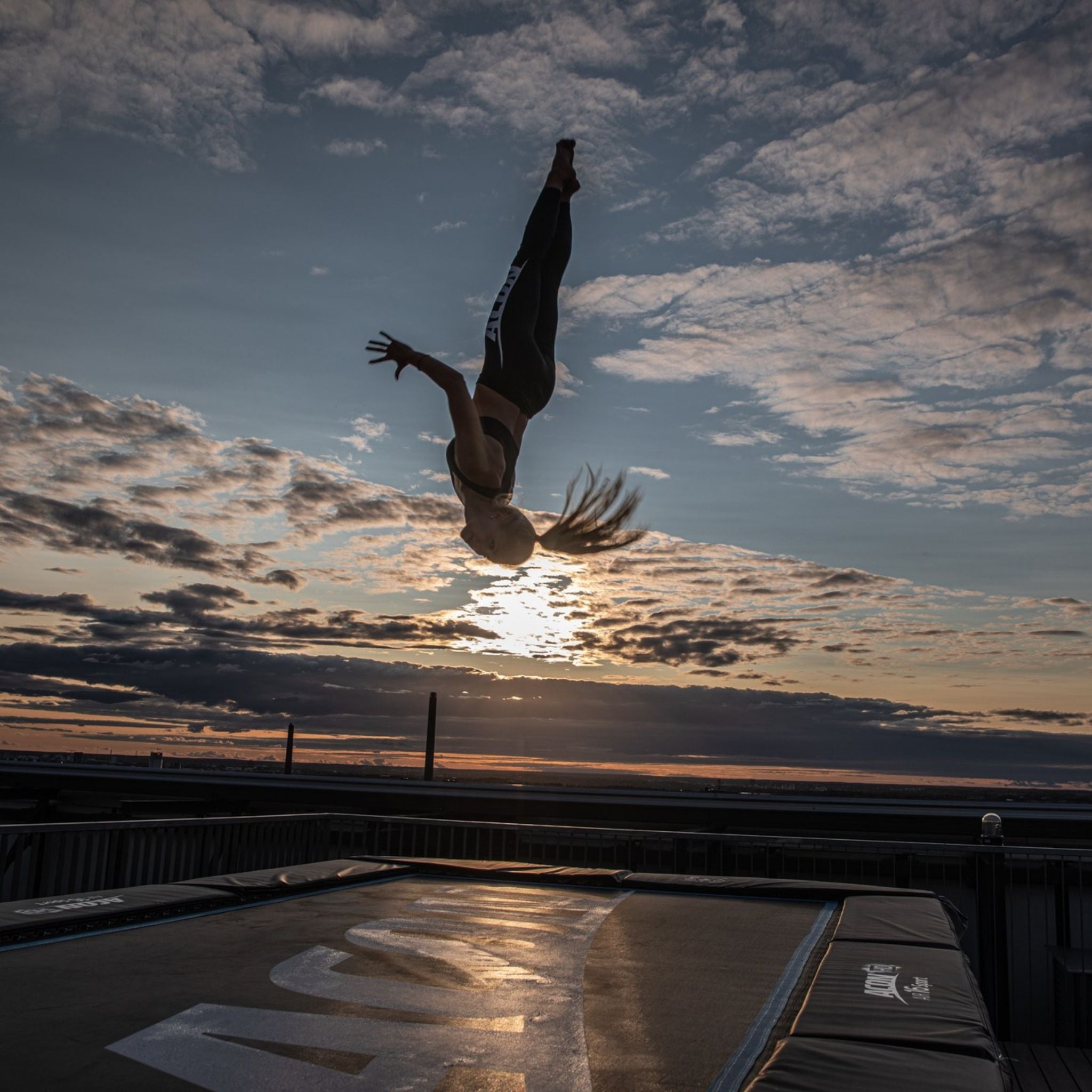 Frau springt draußen auf einem Trampolin (Trampolin Sport)