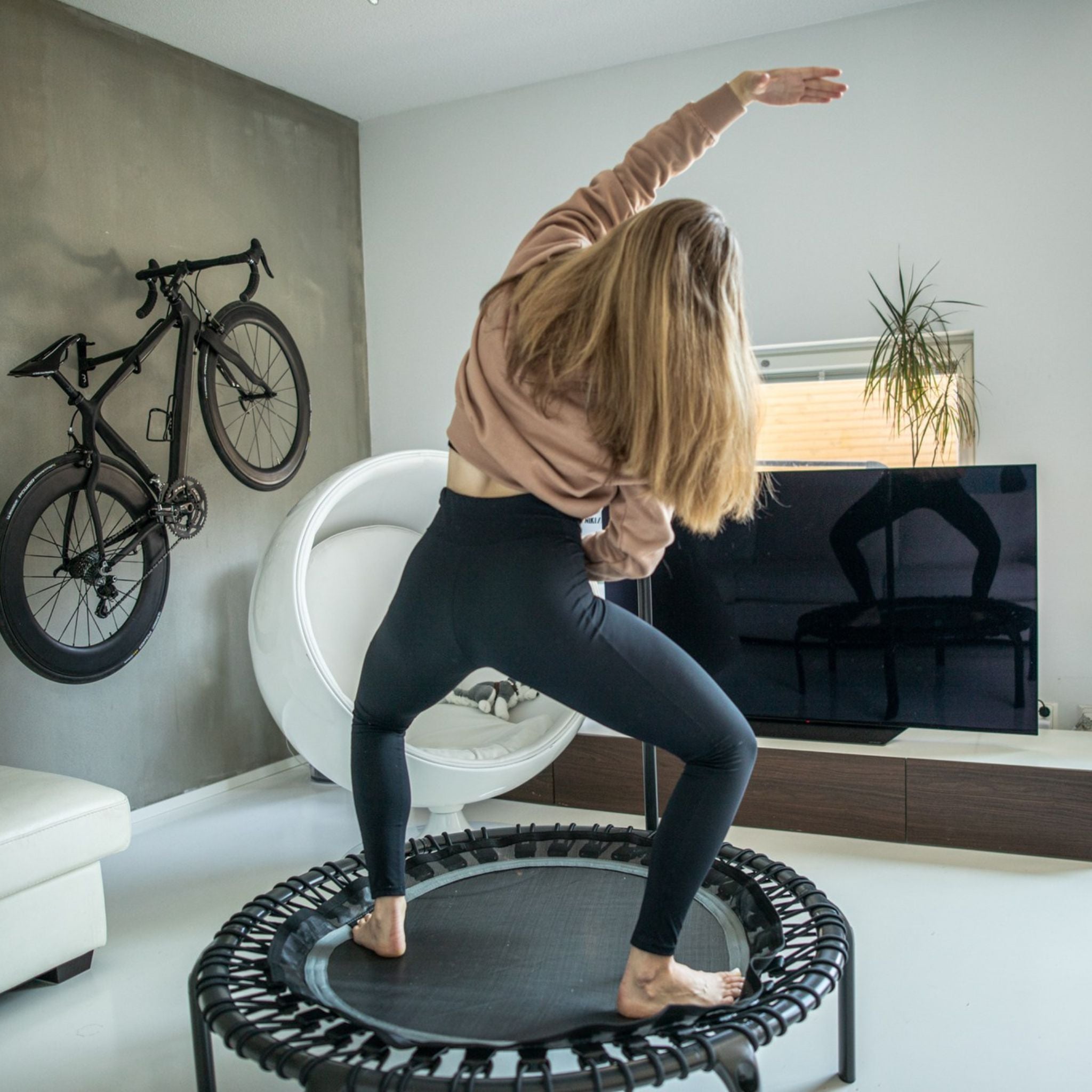 Frau trainiert auf dem Trampolin. Trampolin Übungen für Anfänger