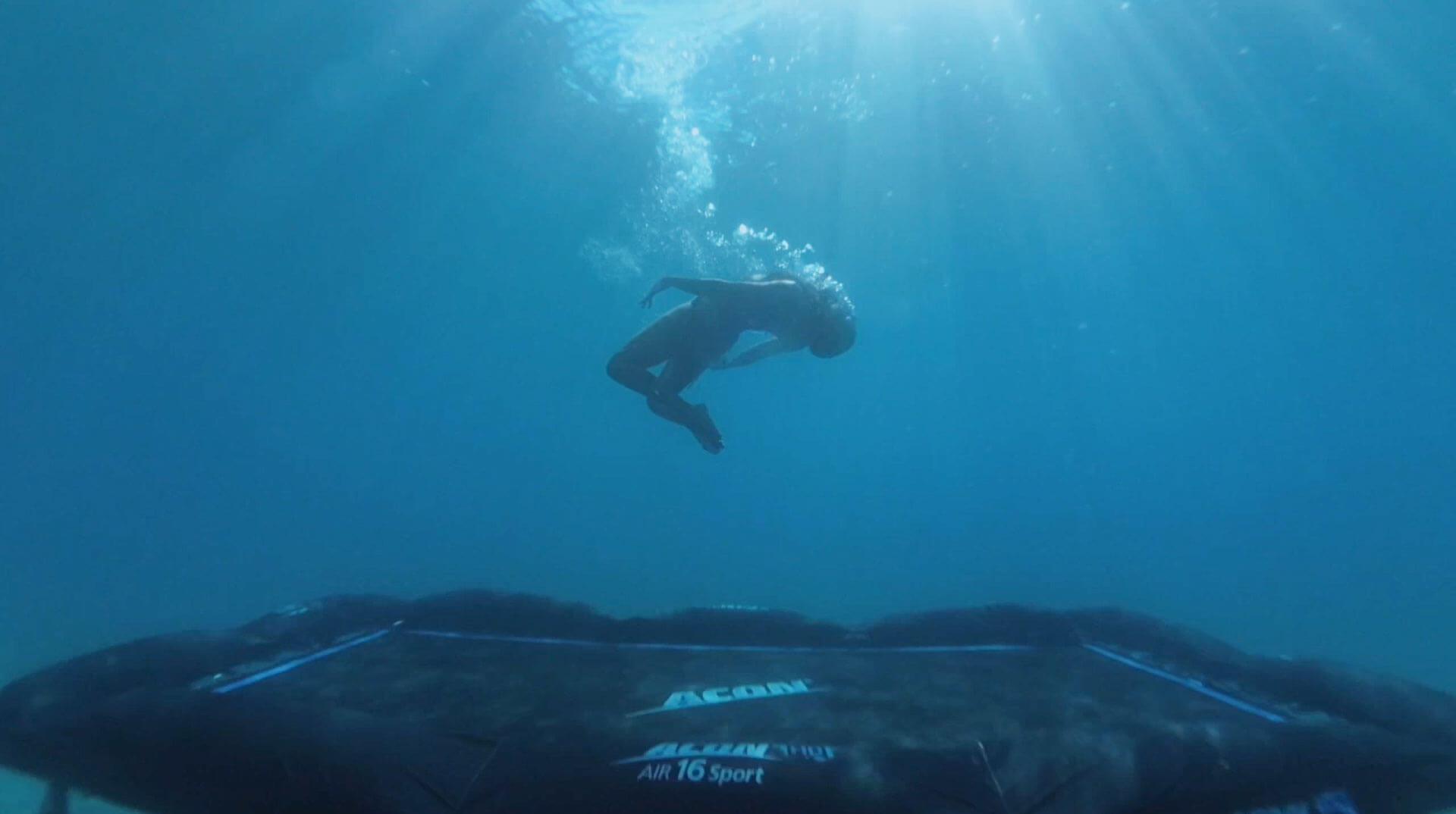 Eine Person, die unter Wasser auf einem Trampolin springt
