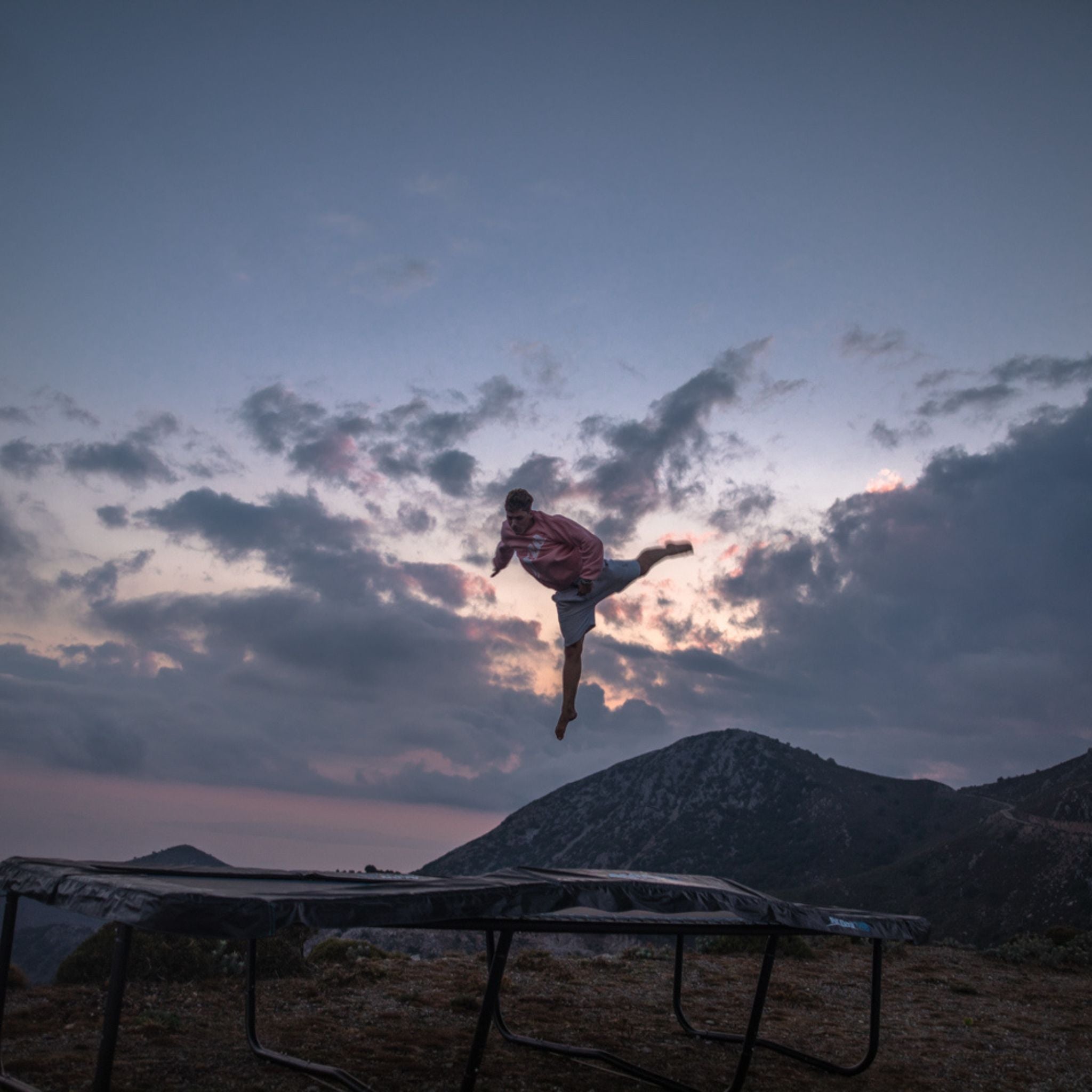 Eine Person springt sicher auf einem Trampolin bei Dämmerung, um Unfallgefahr beim Trampolinspringen zu vermeiden.