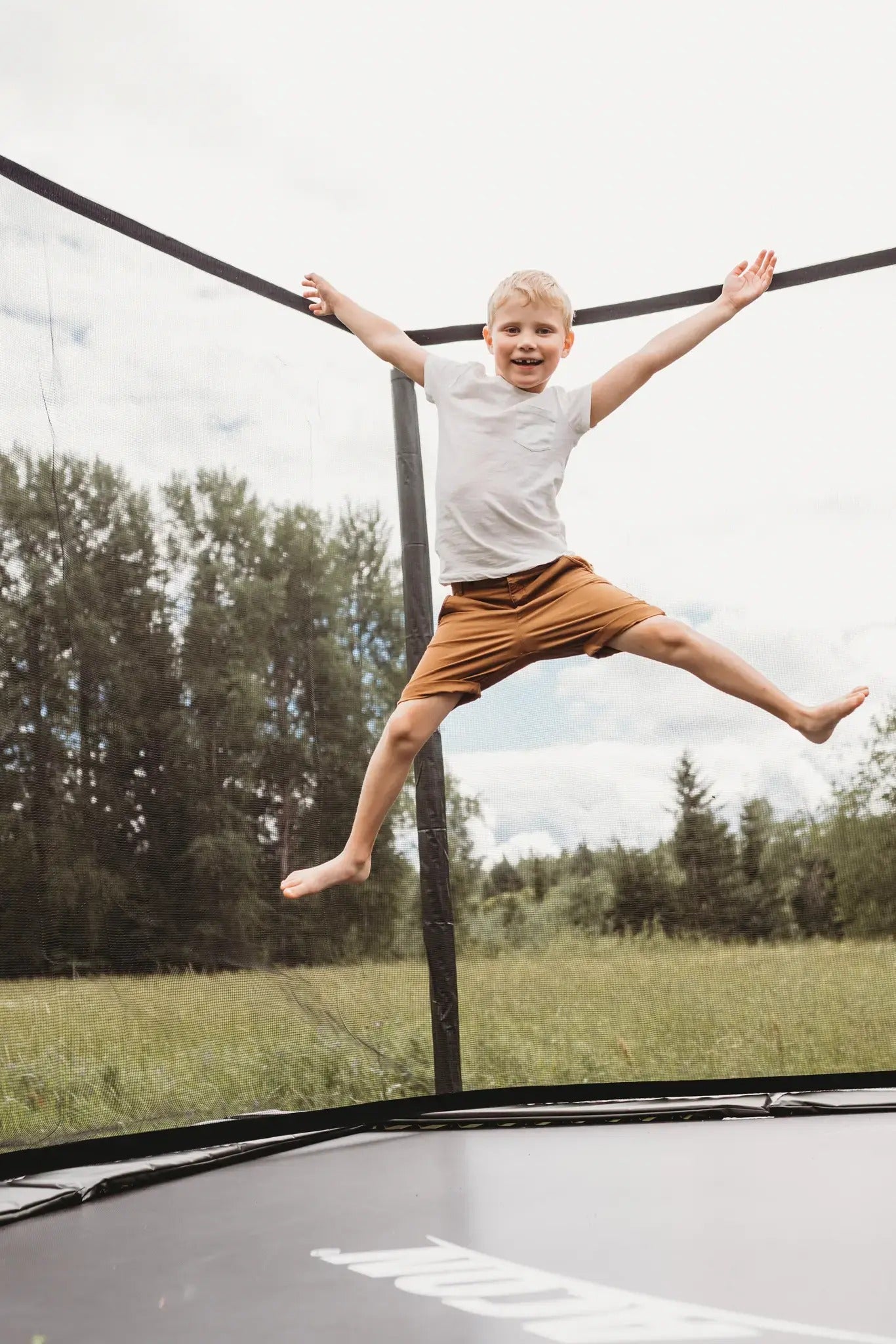 Junger Junge springt hoch auf einem Acon-Trampolin.