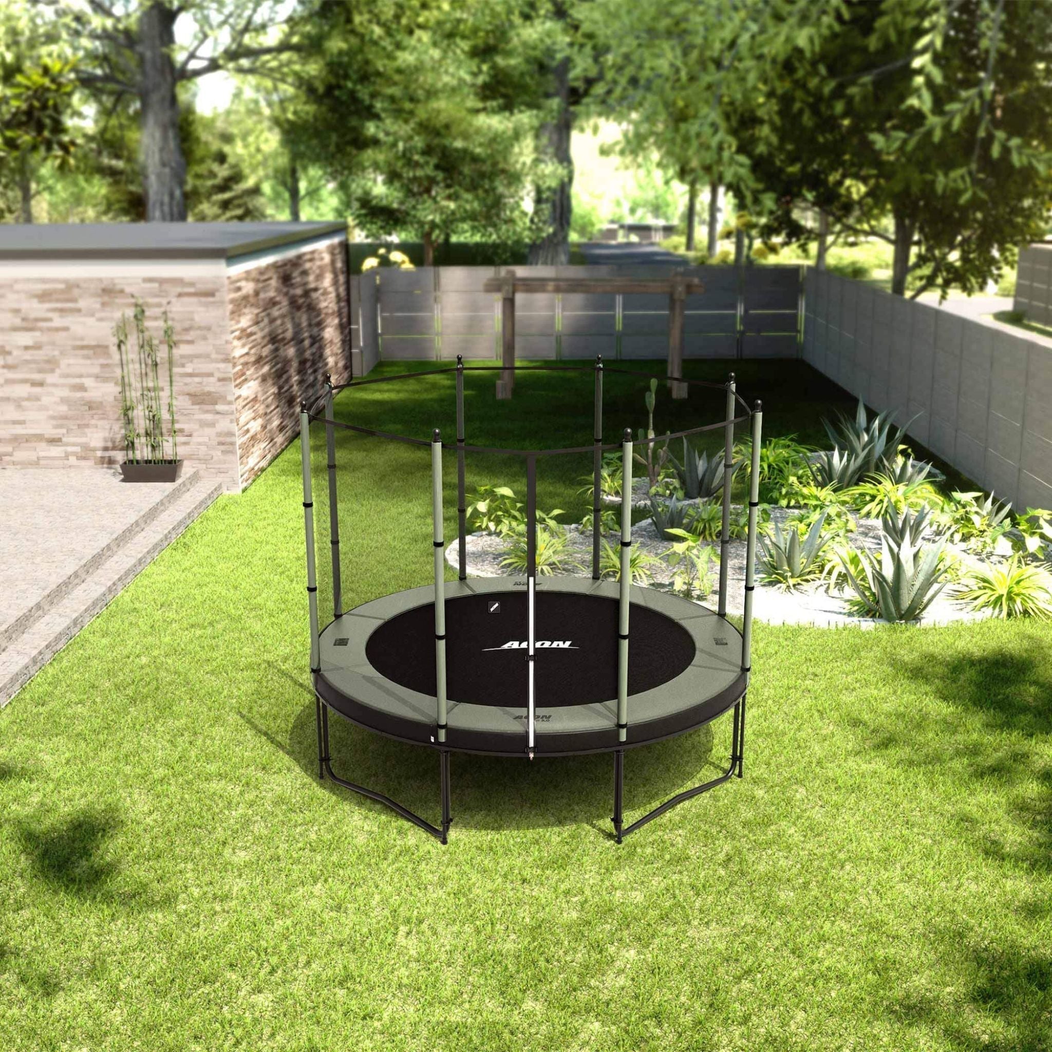 Ein rundes Acon-Trampolin mit Sicherheitsnetz steht in einem Garten mit grünem Rasen, Holzzaun und üppigen Pflanzen im Hintergrund.