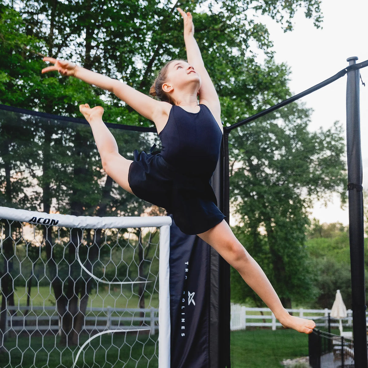 Mädchen macht einen gymnastischen Sprung auf einem Acon-Trampolin.