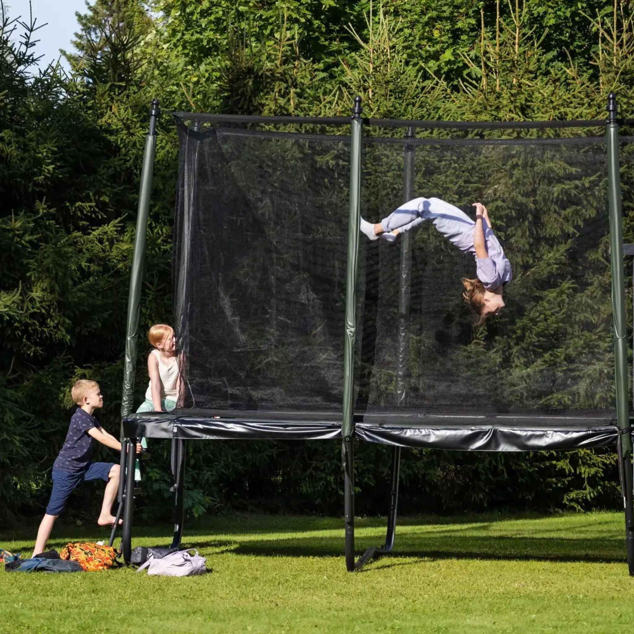 Kinder hüpfen auf einem Trampolin im Garten