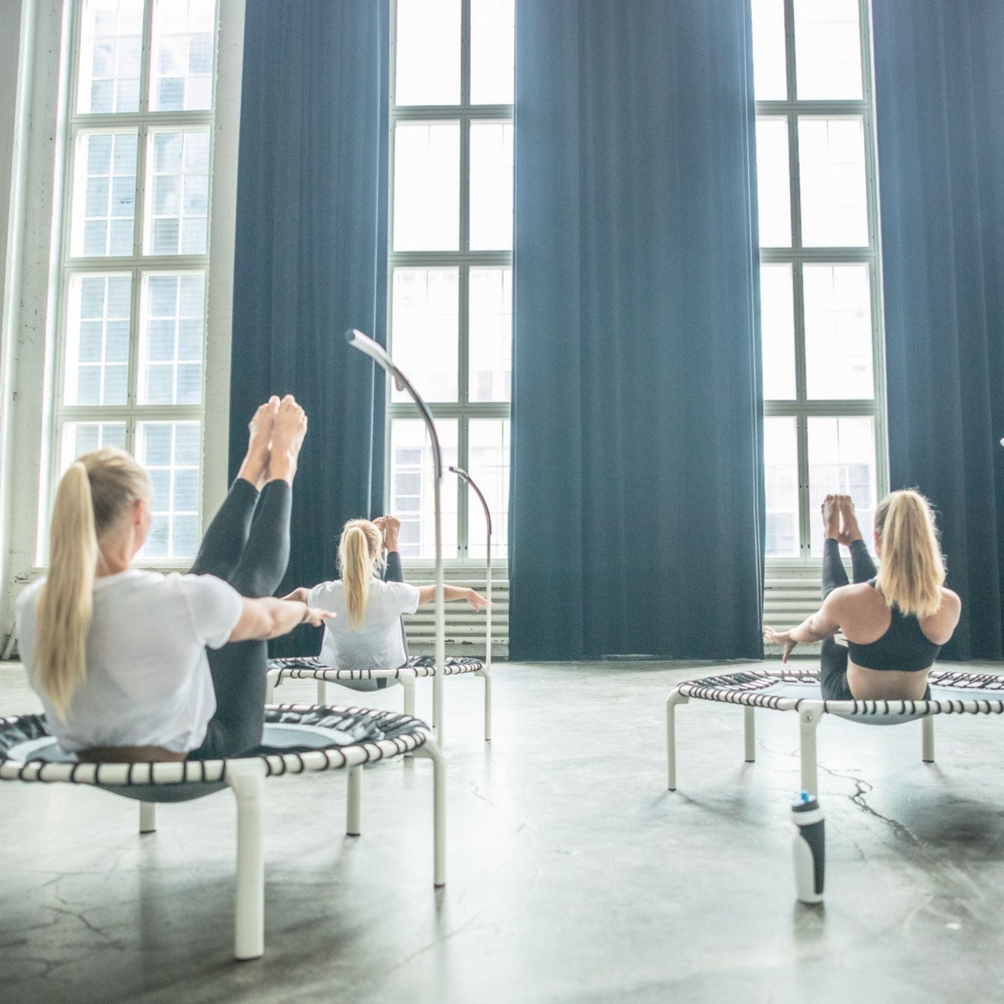 Eine Gruppe von Frauen trainiert in Intervallen auf Trampolinen