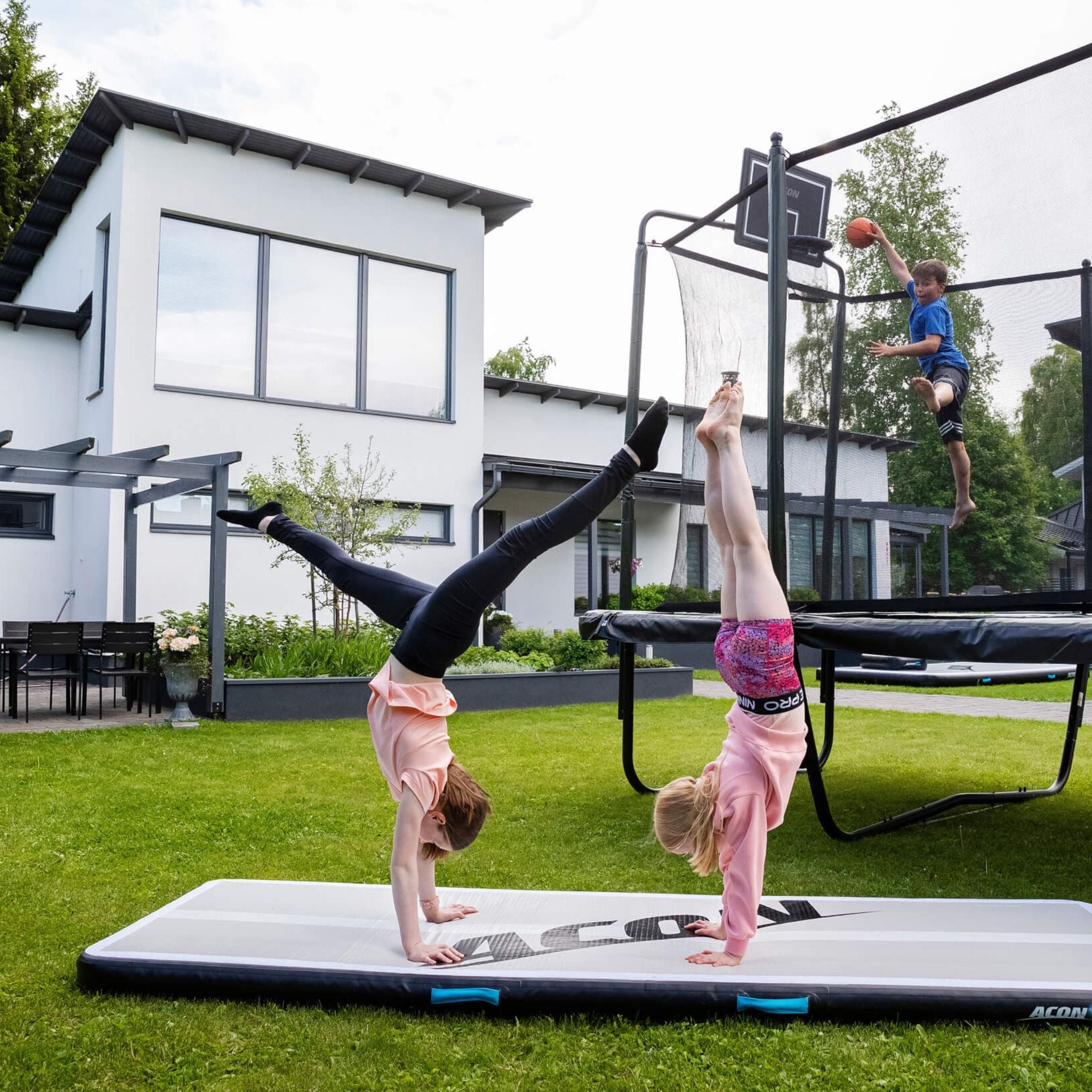 Zwei Kinder üben einen Handstand im Garten des Hauses