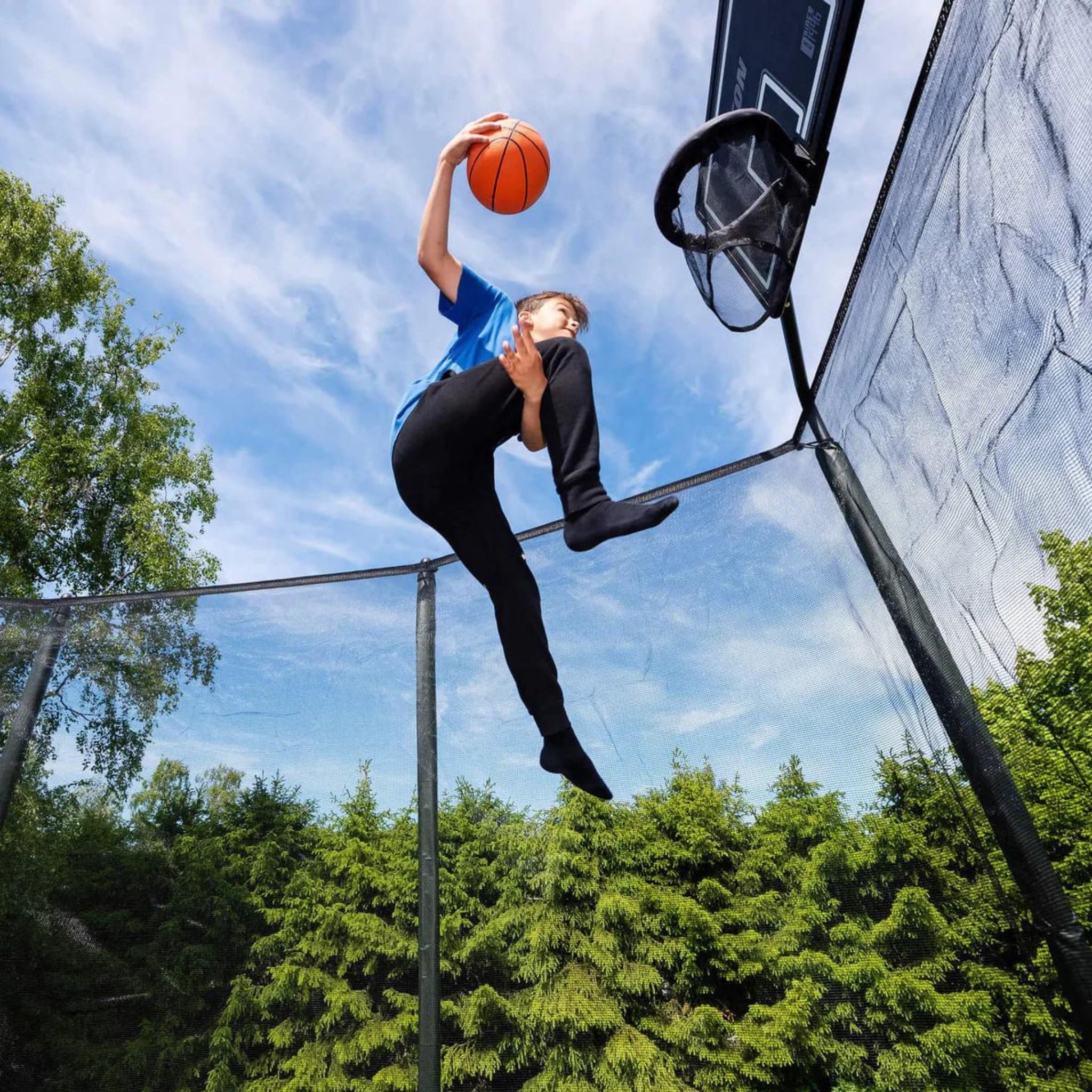 Junge dunked Basketball. Trampolin Basketball.