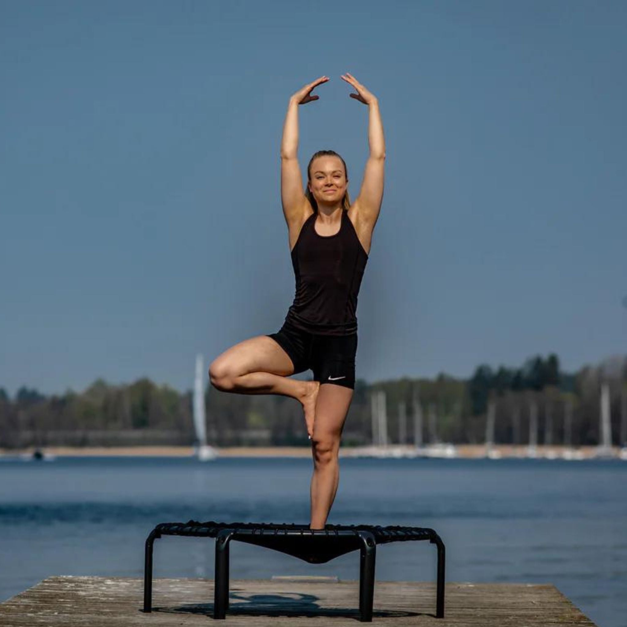Frau praktiziert Yoga mit Trampolin Bekleidung