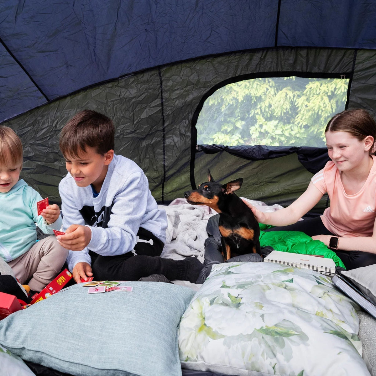 Kinder mit Hund auf einem Trampolin