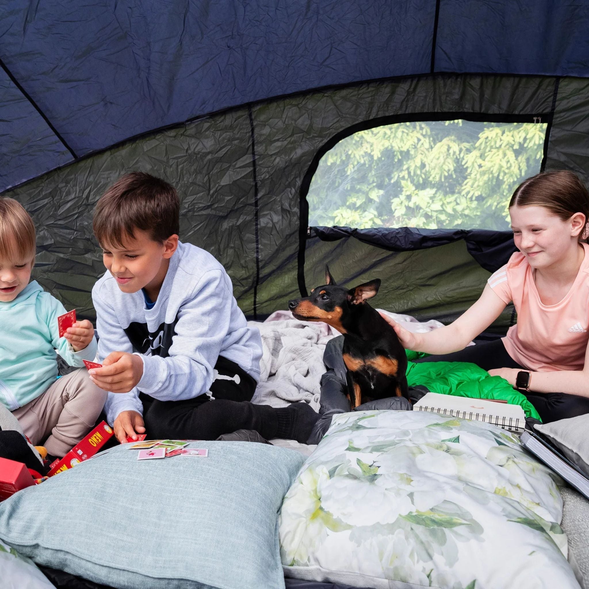 Kinder mit Hund auf einem Trampolin