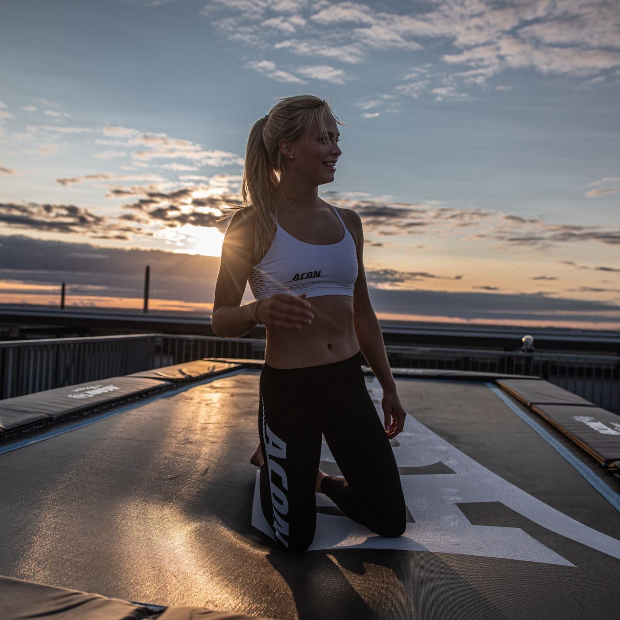 Frau kniet auf dem Trampolin. Trampolin reparieren.
