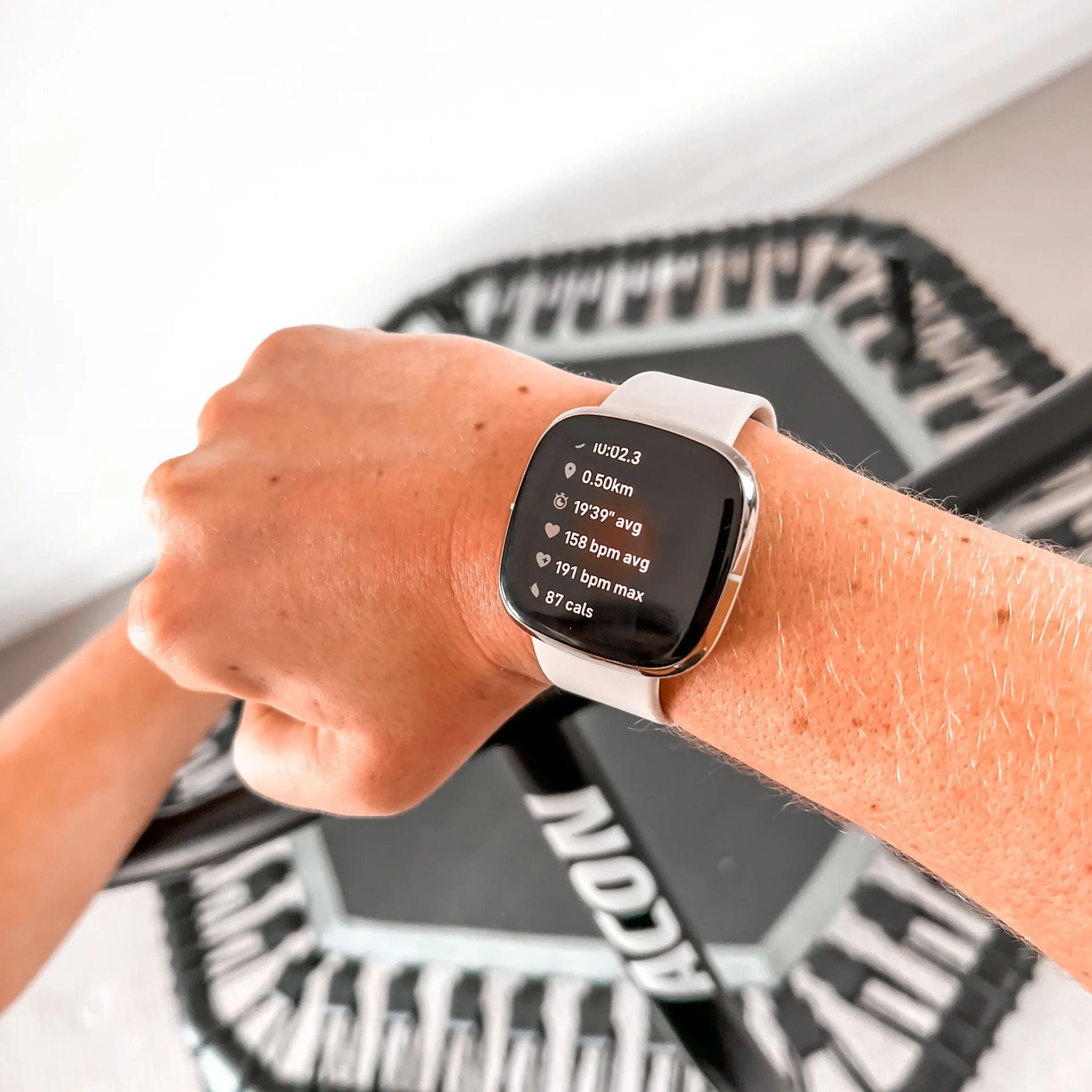 Smartwatch mit Tracking-App vor einem Acon Trampolin