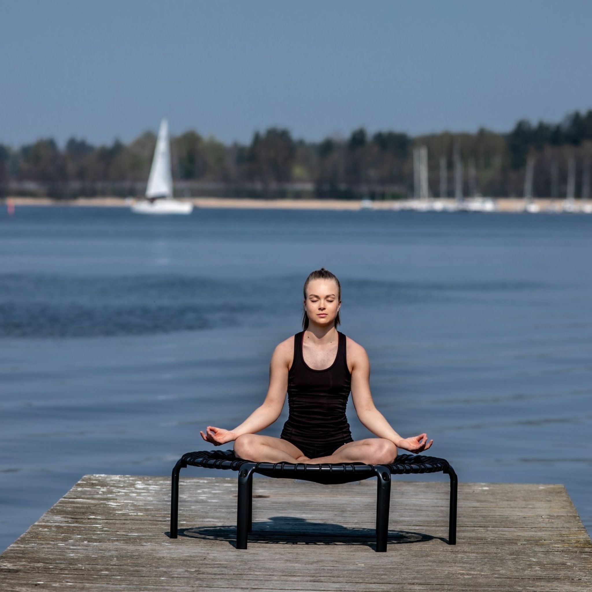 Frau auf Trampolin. Trampolin Yoga.