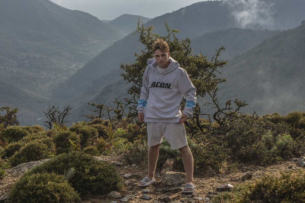 Ein Mann mit ACON Hoodie in einer Waldlandschaft