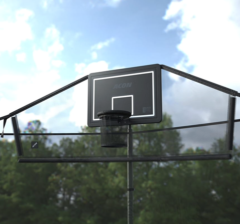 Außenaufnahme des Acon-Trampolinkorbs für ein rundes Trampolin und des dazugehörigen Backnets von unten, mit blauem Himmel, umliegenden Bäumen und Wolken.