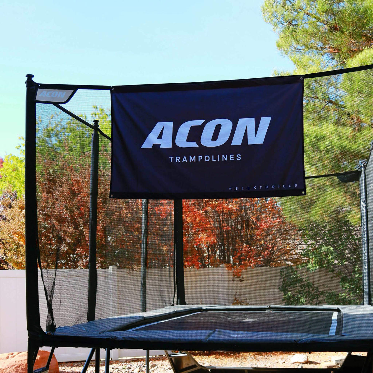 Schwarze ACON-Flagge, befestigt am Sicherheitsnetz eines Trampolins.