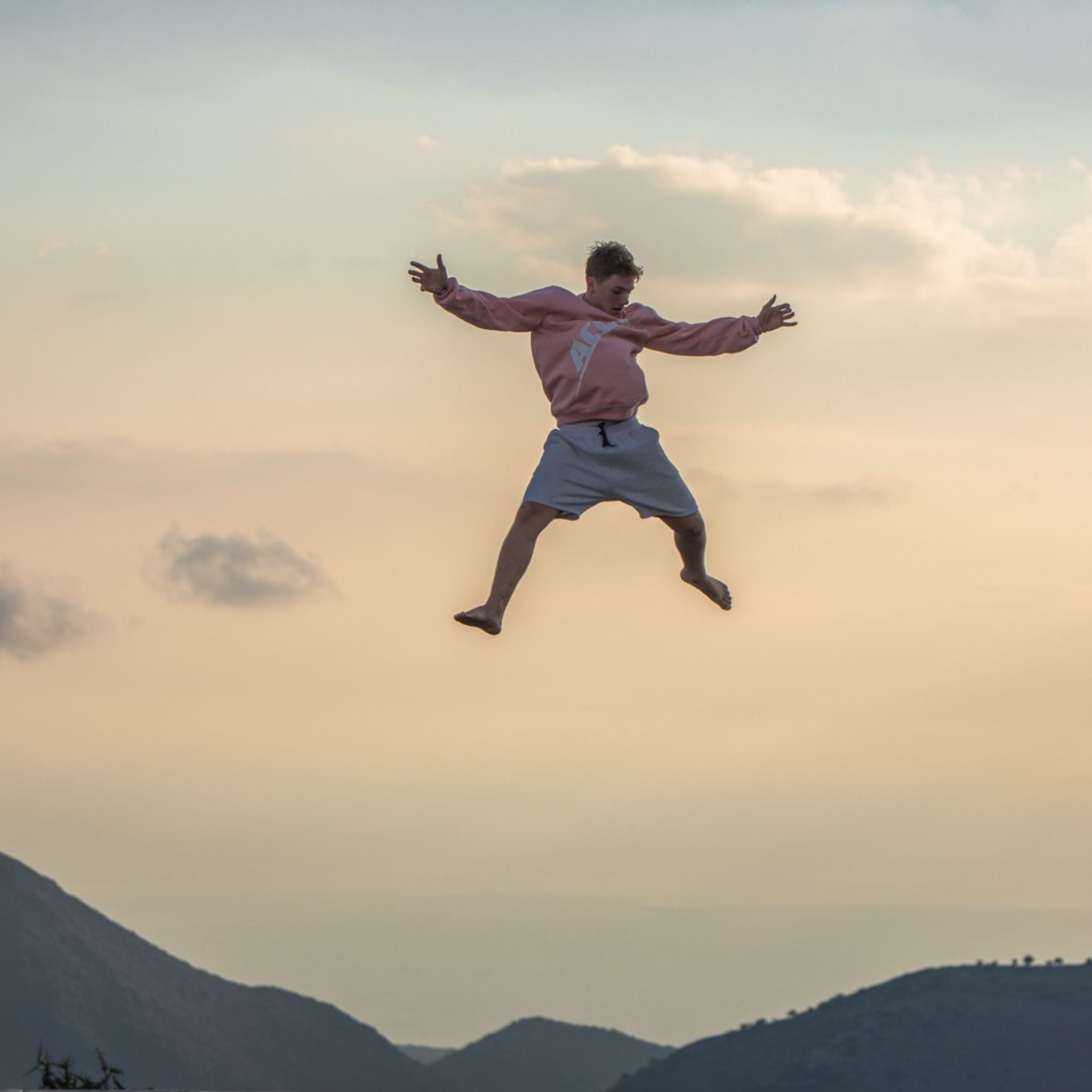 Mann hüpft auf Trampolin im Sonnenuntergang