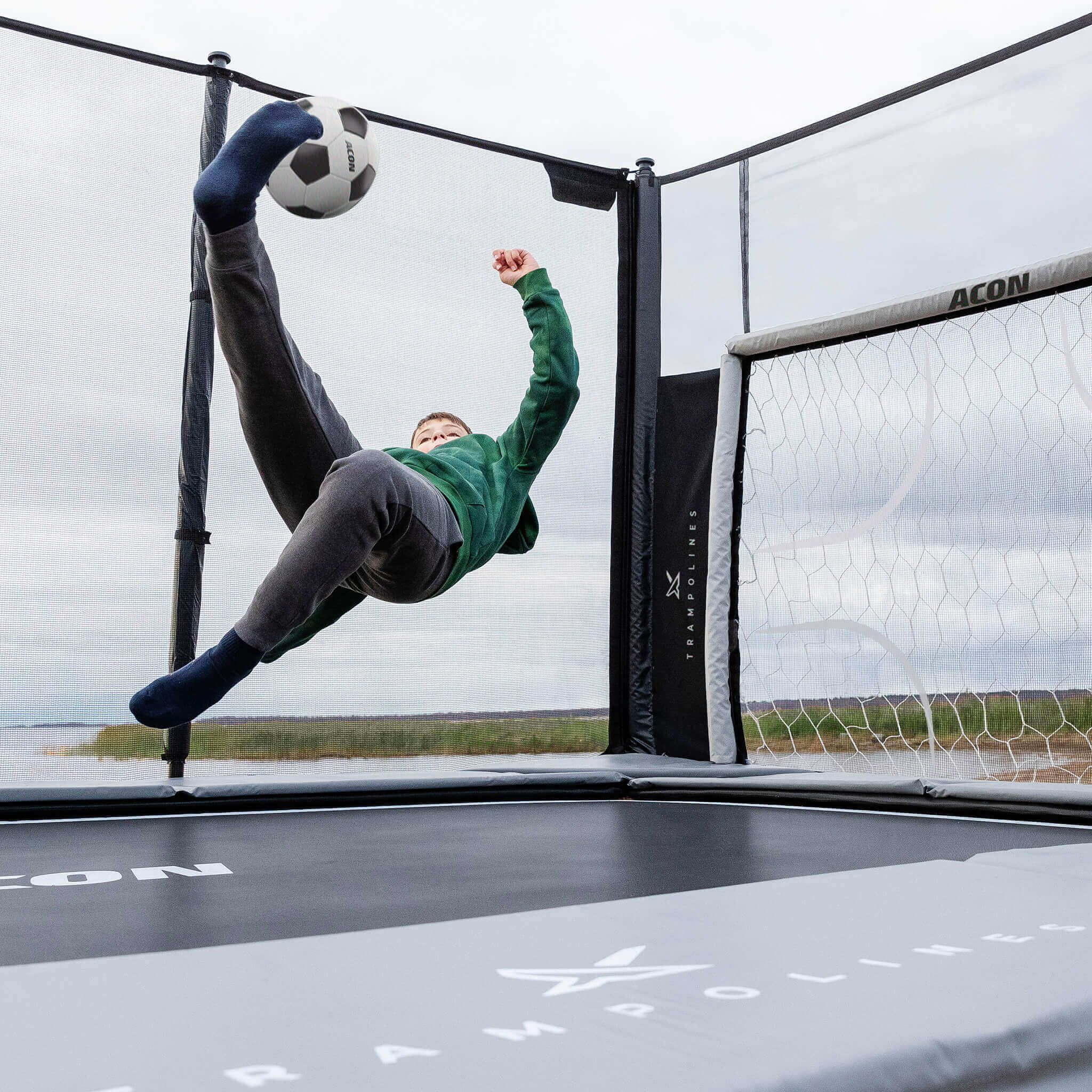 Zwei Jungen spielen Fußball auf einem Acon X 17 Trampolin mit Fußballfarbe