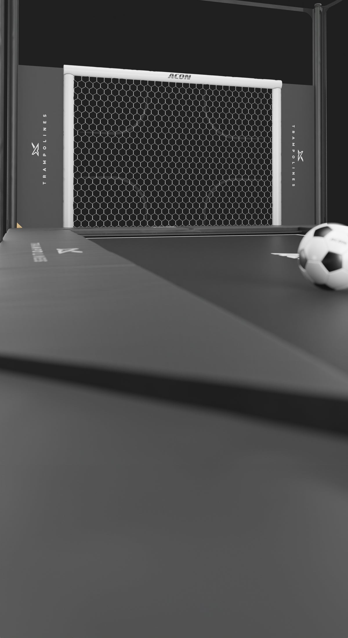 Fußballtor für Trampolin mit Fußball auf schwarzer Oberfläche.