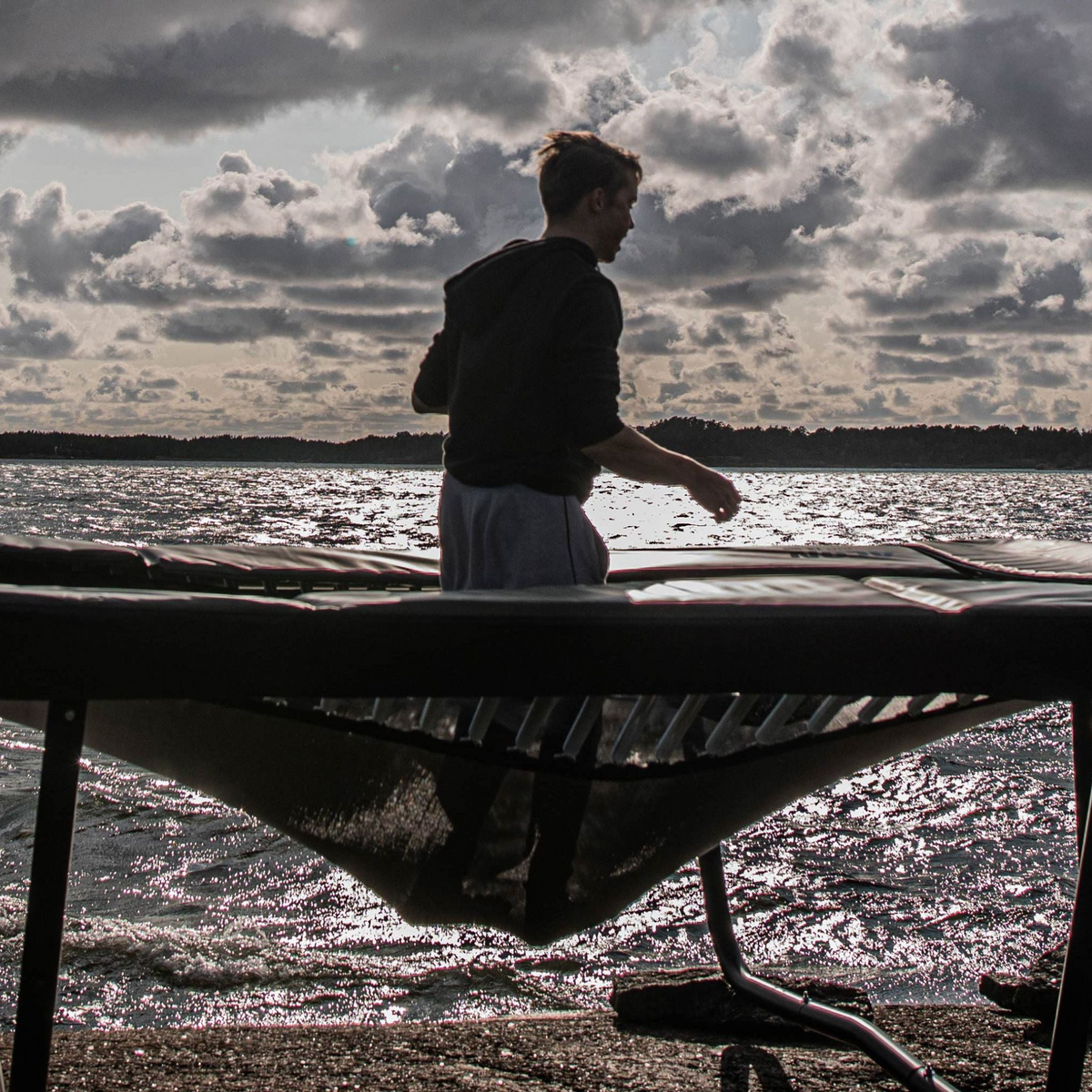 Junge hüpft Trampolin am Meer