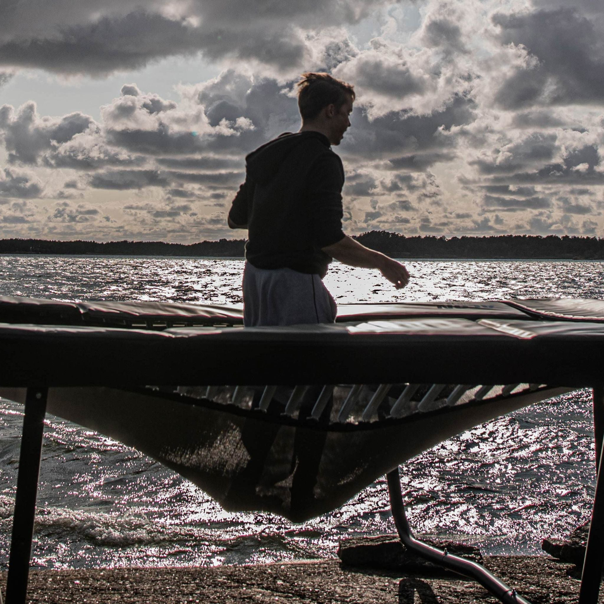 Junge hüpft Trampolin am Meer