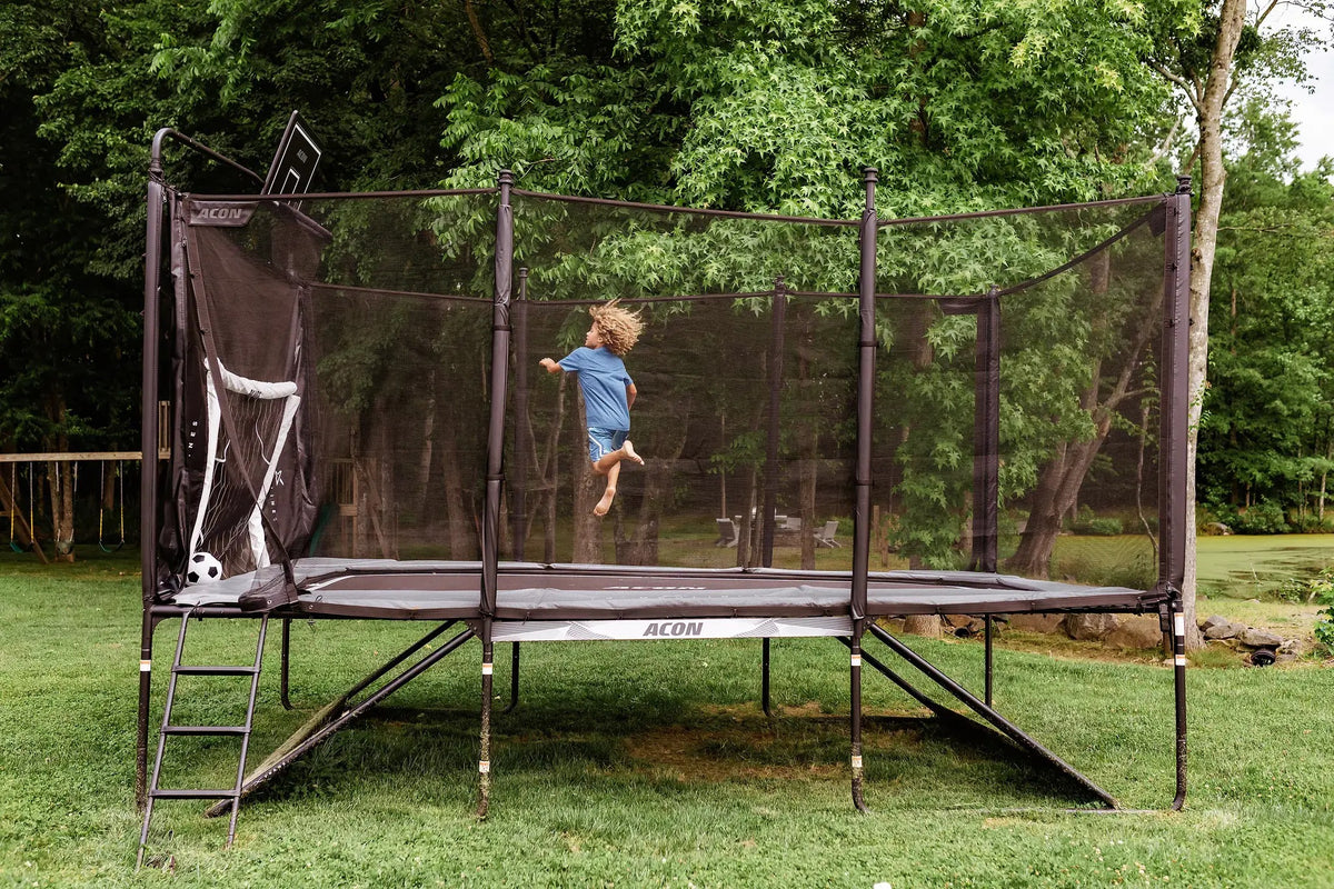 Kind springt auf einem Acon-Trampolin mit angebrachtem Fußballtor.
