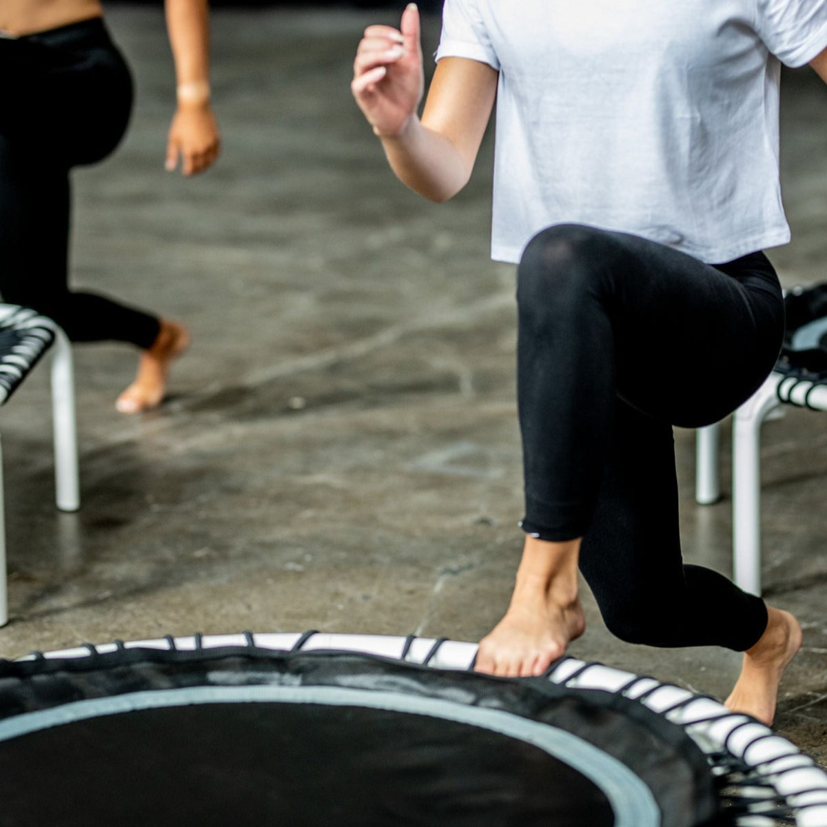Frau trainiert low Lunges auf einem Trampolin