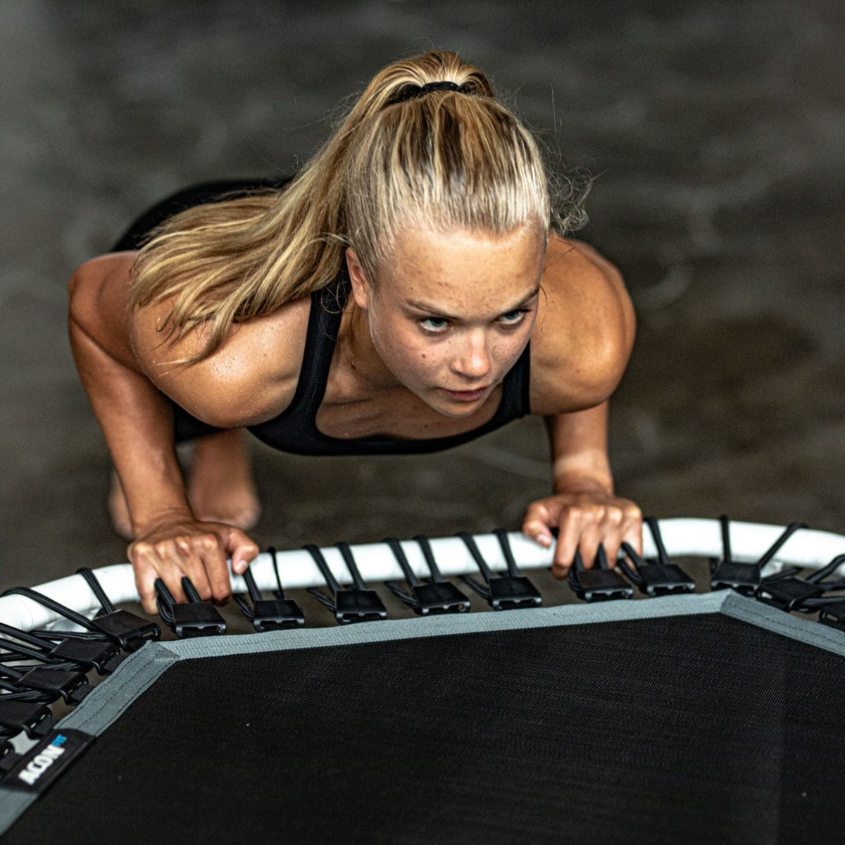 Frau trainiert Liegestütze auf einem Trampolin
