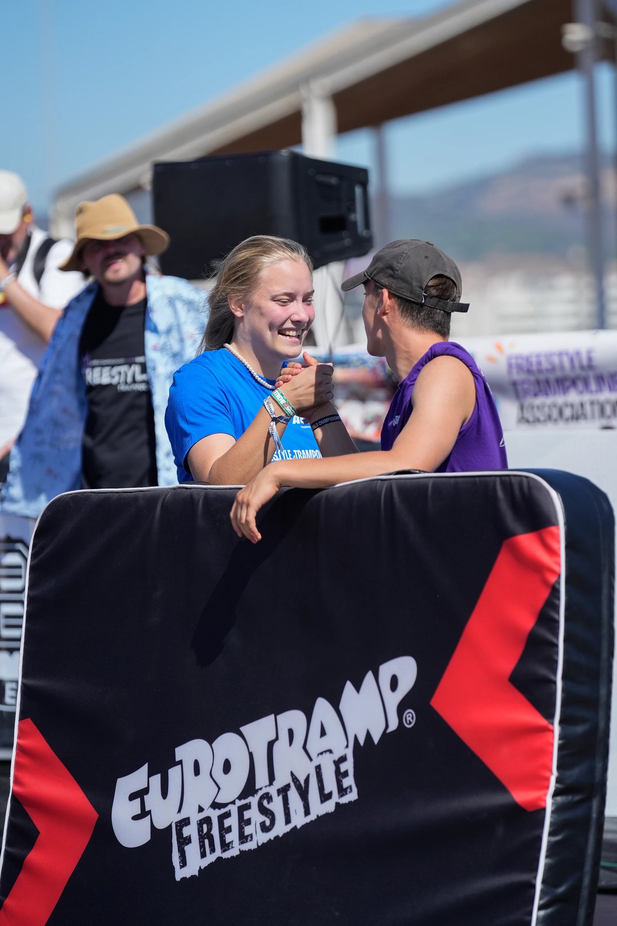 Teilnehmer des Trampolinwettbewerbs schütteln sich die Hände.