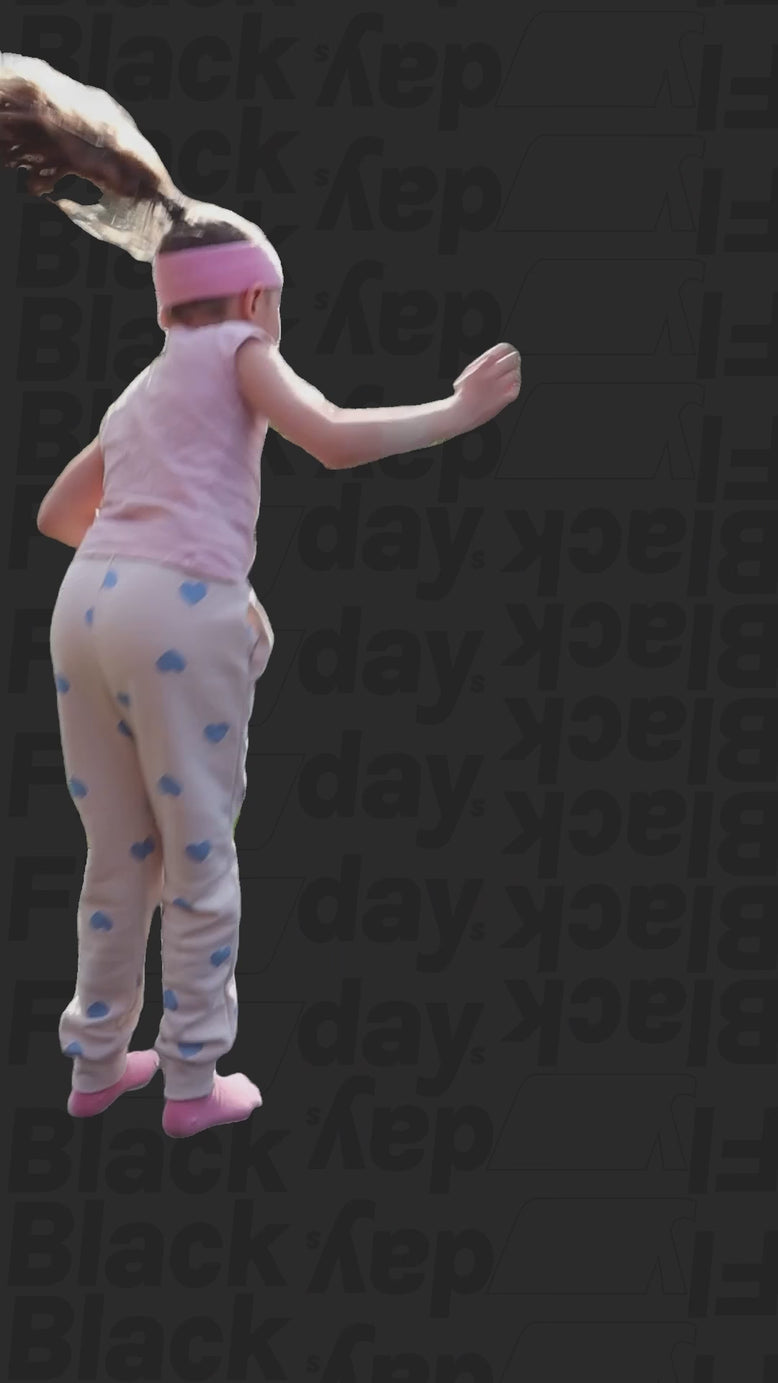 Video von einem kleinen Mädchen mit Acon-Stirnband, das auf schwarzem Hintergrund mit Black-Flydays-Muster hüpft.