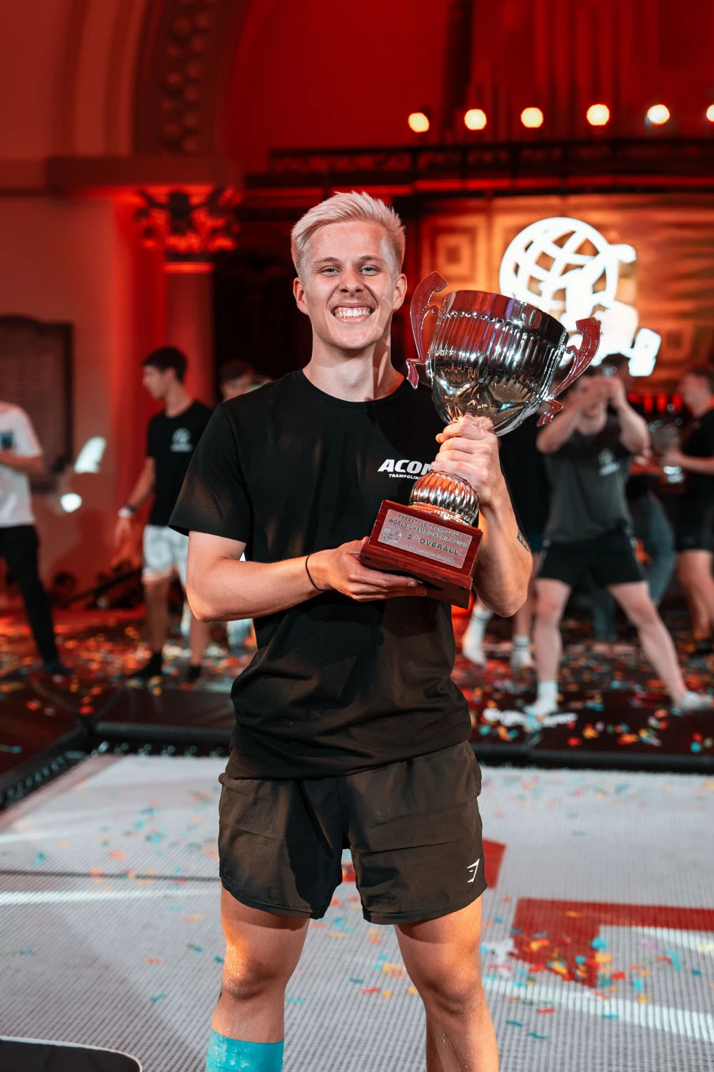 Ein lächelnder Mann hält seinen Pokal in den Händen.