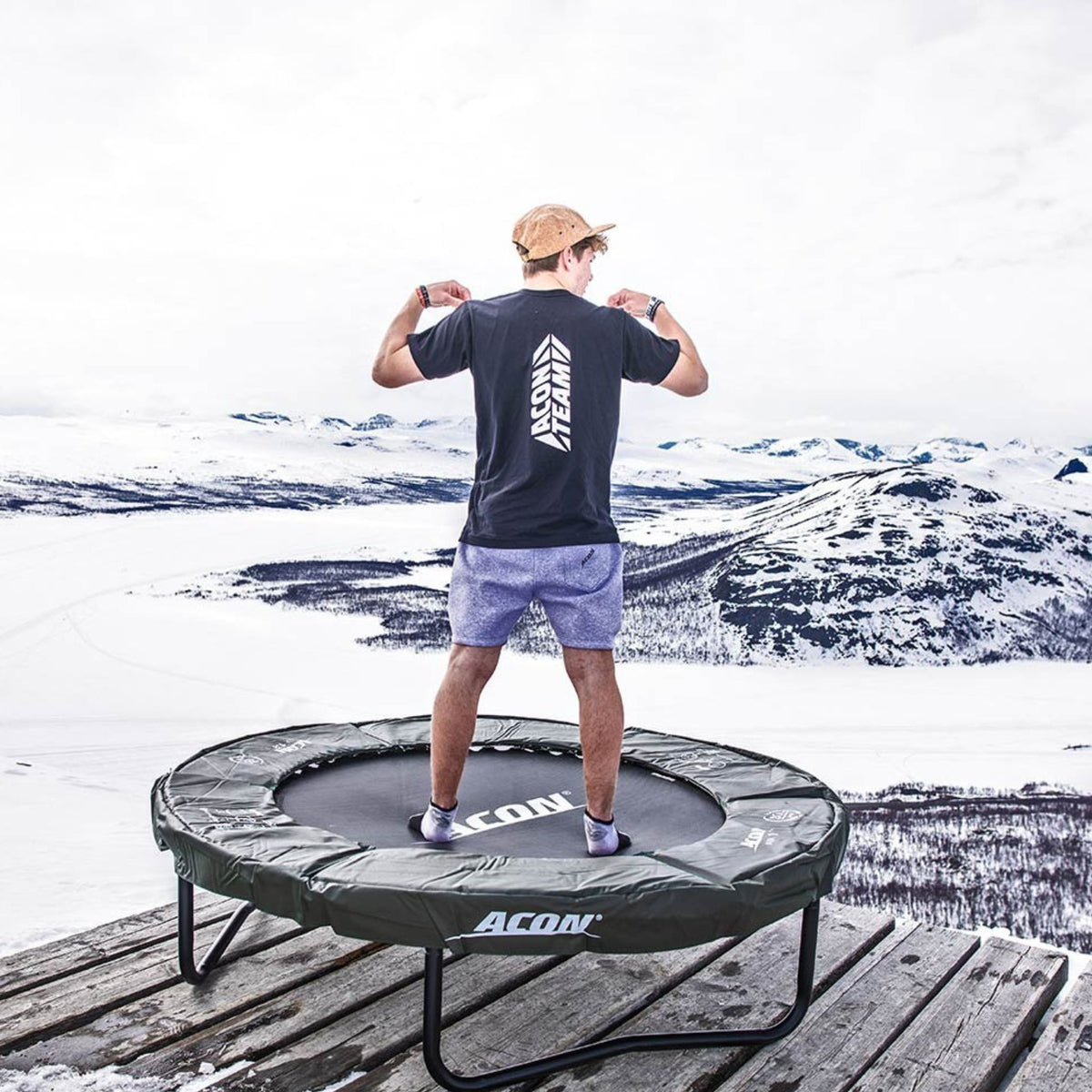 Mann auf Trampolin im Schnee. Spikeball.