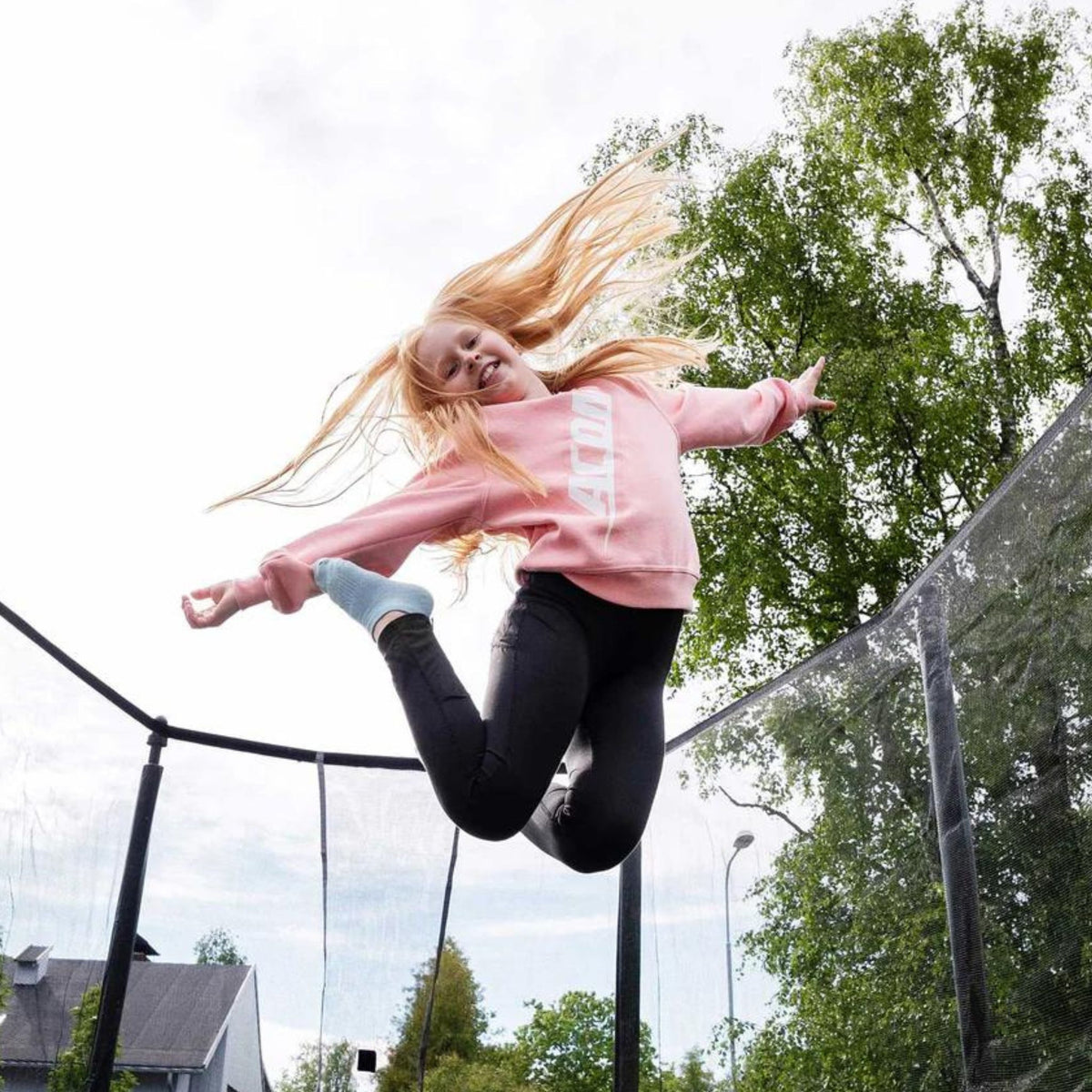 Kind hüpft mit komfortabler Kleidung auf einem Trampolin