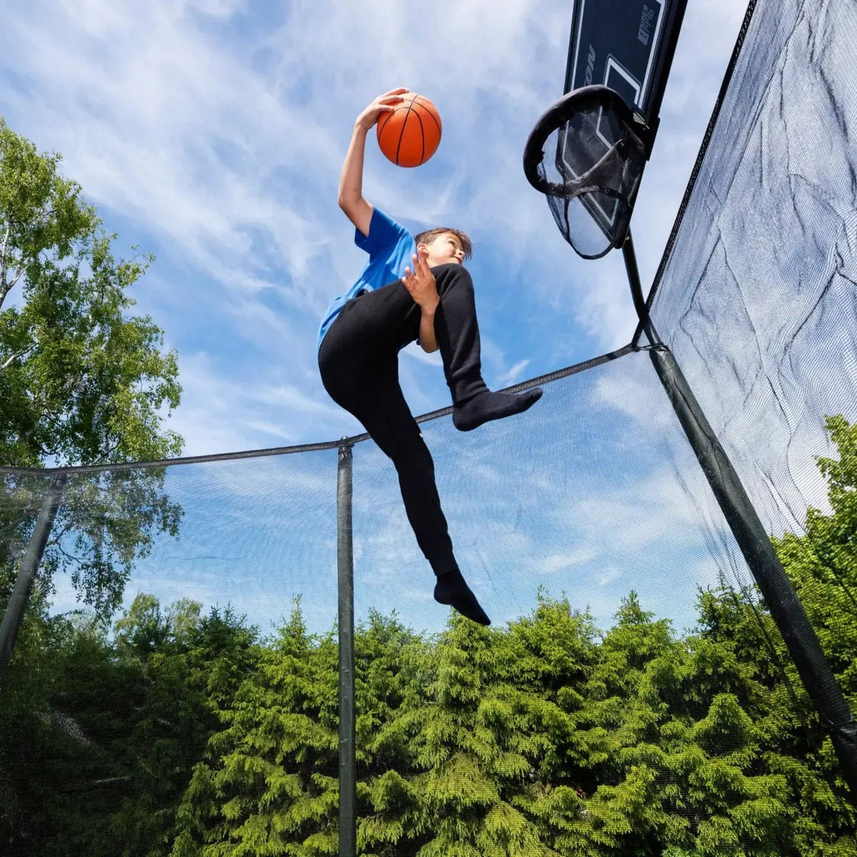 Junge spielt Basketball auf Riesen Trampolin