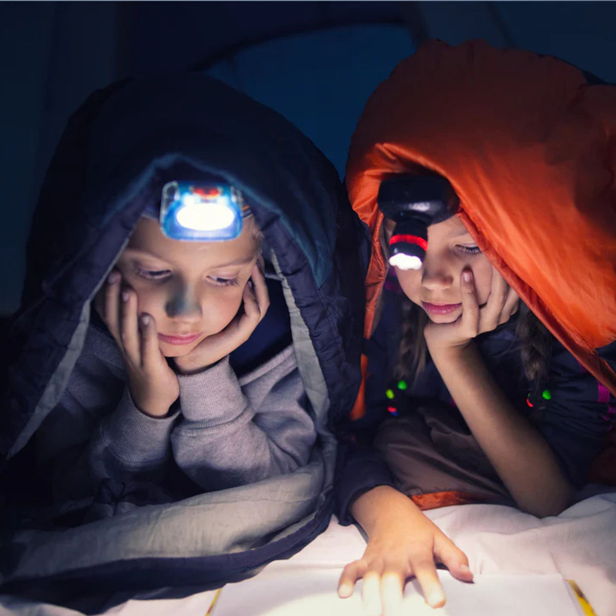 Kinder mit Stirnlampen sitzen in einem Trampolin