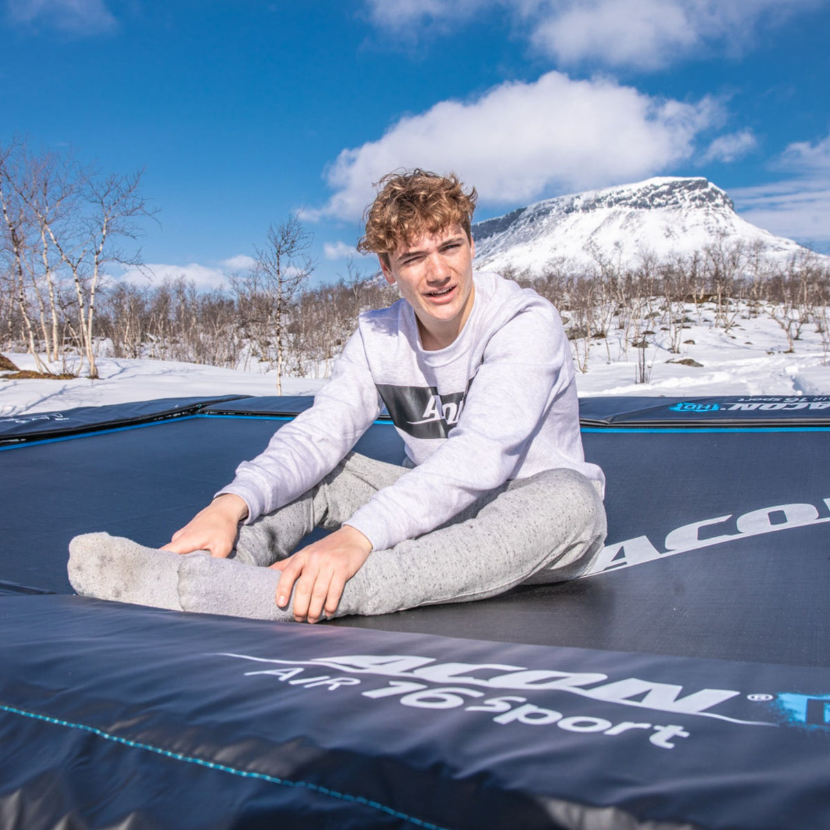 Trampolin Rechteckig Größen junger Mann sitzt auf Trampolin