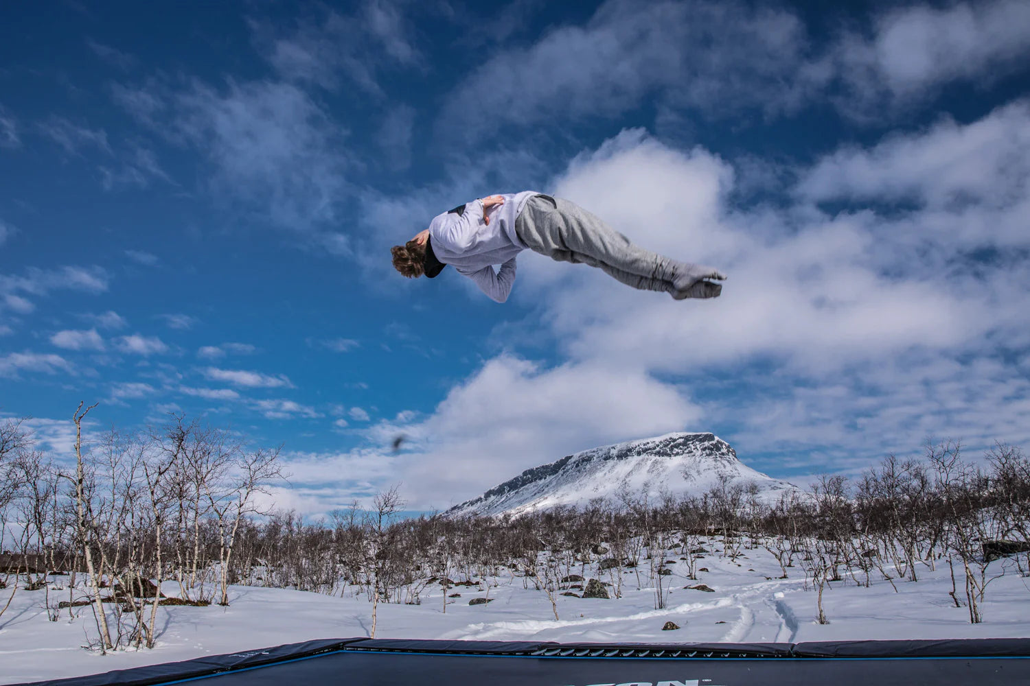 Person springt im Winter auf dem Trampolin