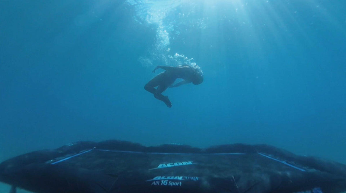 Eine Person, die unter Wasser auf einem Trampolin springt 